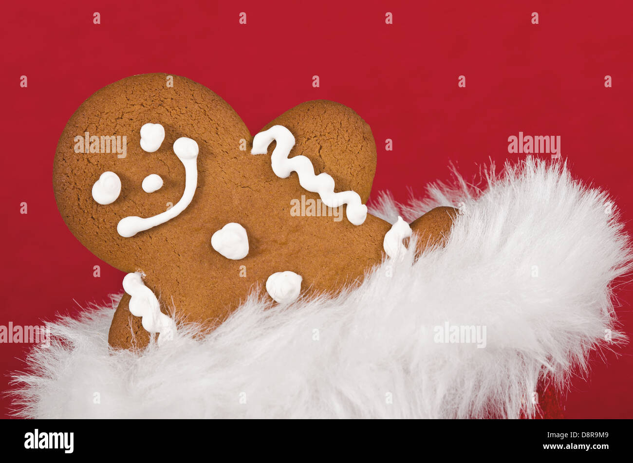 Gros plan du gingerbread man peeking out from cookie sac cadeau de Noël sur fond rouge Banque D'Images