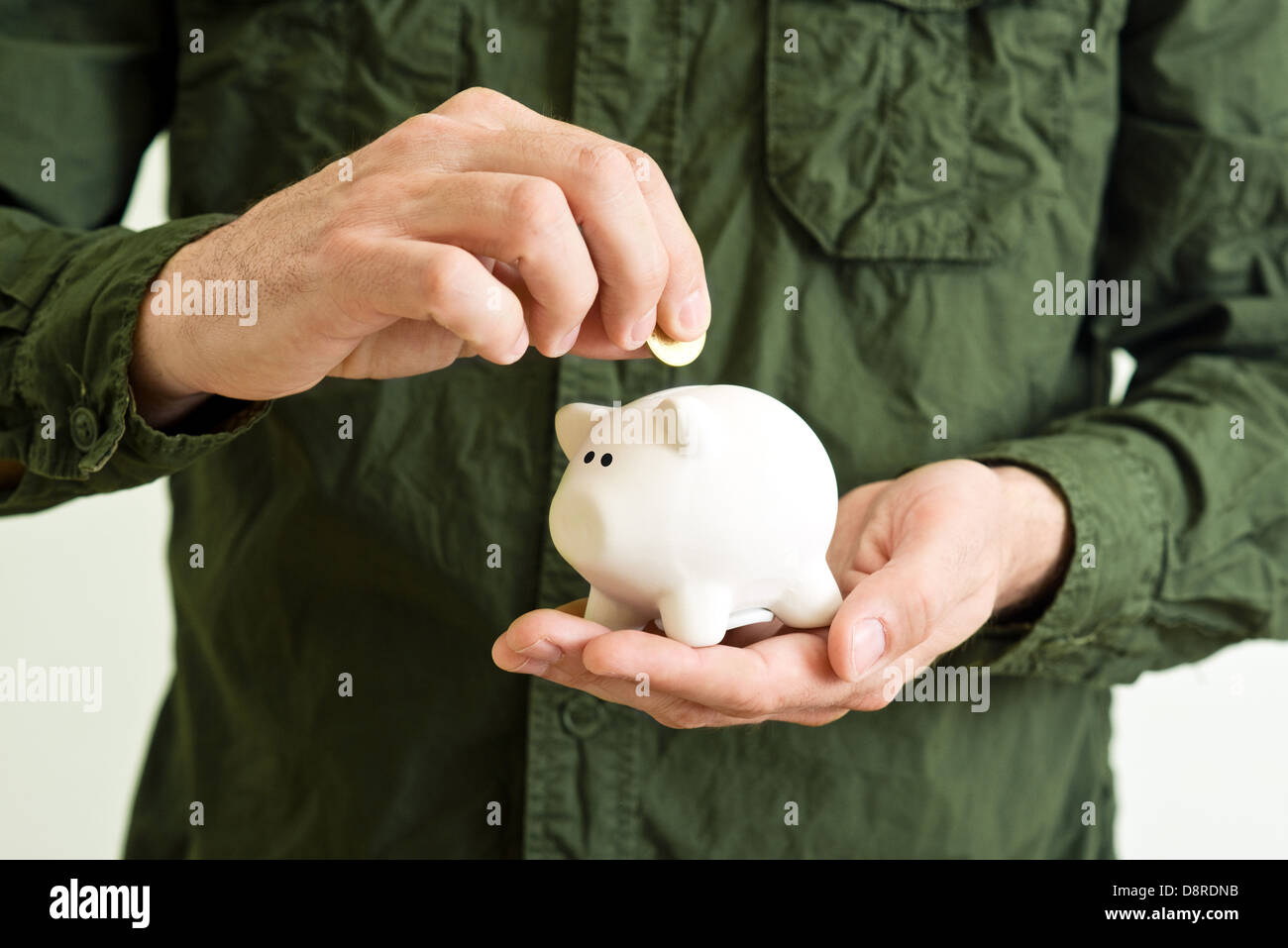 Piggy coin bank au creux des mains de l'homme. Banque D'Images