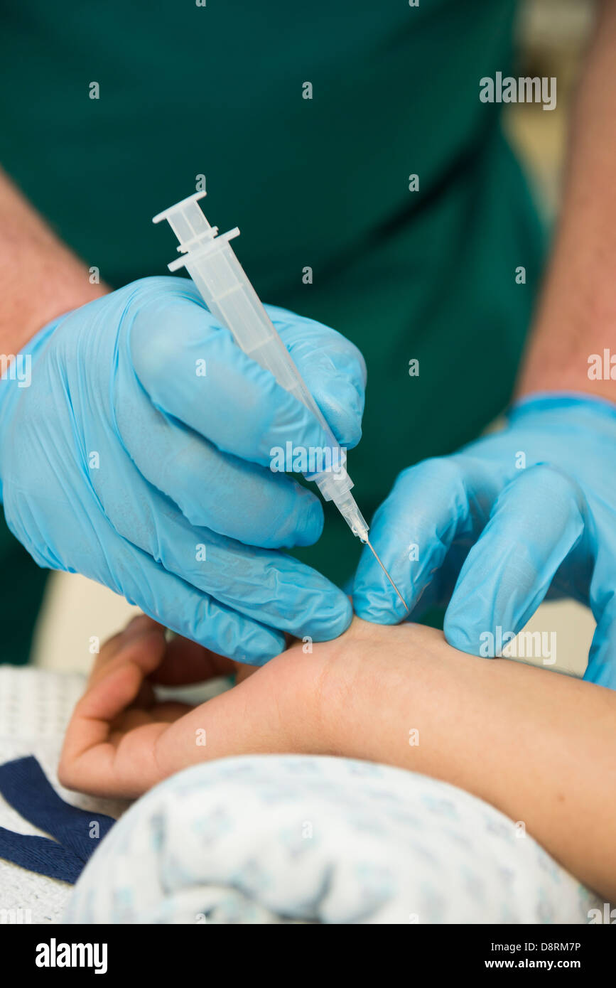 Une seringue de sang en cours de préparation à l'insertion dans un hôpital. Banque D'Images