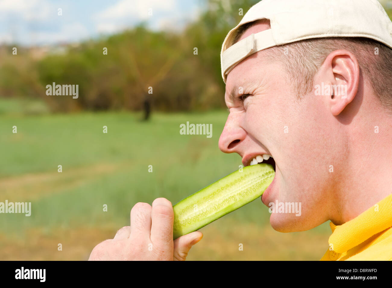 Man biting concombre Banque D'Images