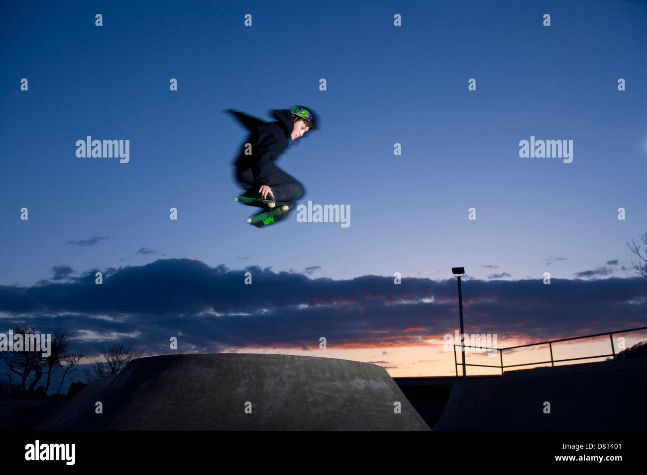 Les jeunes Inline Skater sautant dans un skate park. Banque D'Images