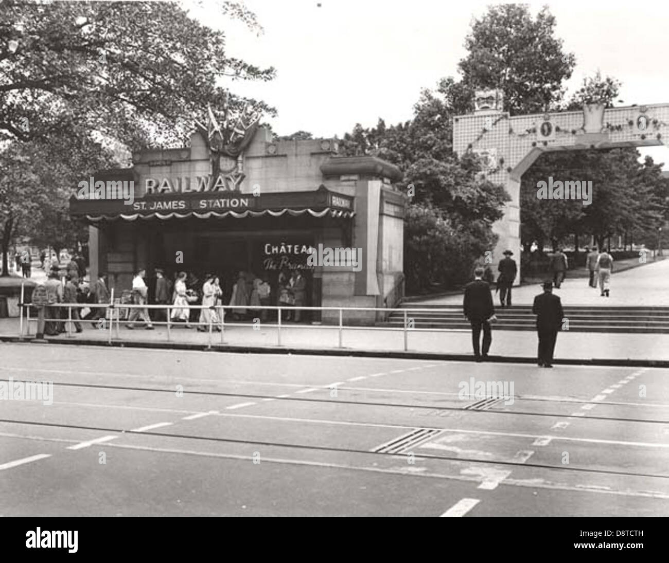 La gare St James de Sydney, représentée en noir et blanc, présente des éléments décoratifs et des piétons sur Elizabeth Street, près de Hyde Park. L'image met en valeur les visites royales et l'infrastructure historique de Sydney. Banque D'Images