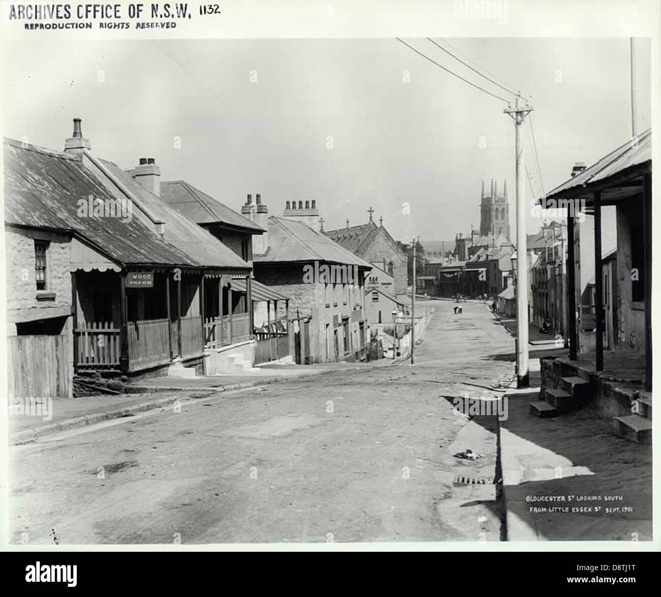 Cette photographie historique capture Gloucester Street dans The Rocks, Sydney, vue vers le sud depuis Essex Street. L'image fait partie de l'étude photographique Rocks Resumption, offrant un aperçu du paysage urbain passé et des caractéristiques architecturales de la région en noir et blanc. Banque D'Images