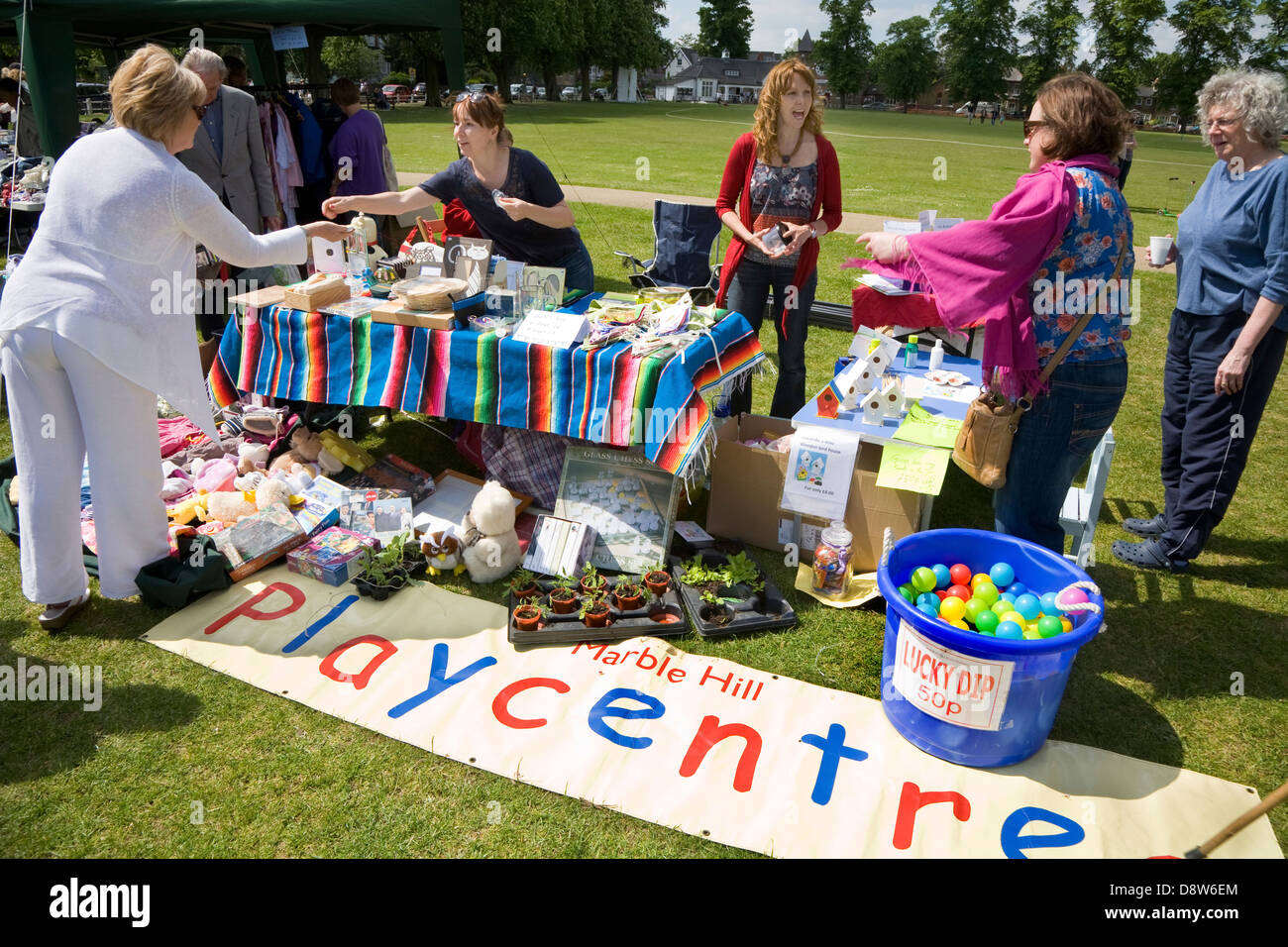 Un bénévole sert un client à un organisme de bienfaisance bric-a-brac & jumble sale stand à une foire verte de Twickenham. Twickenham. Londres. Banque D'Images