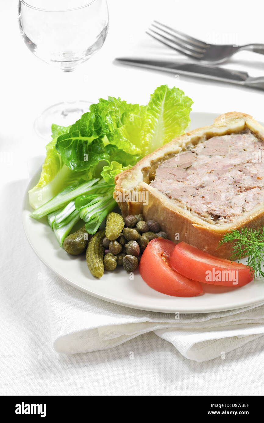 Une tranche de pâté en croûte avec cos de la laitue et des cornichons Banque D'Images