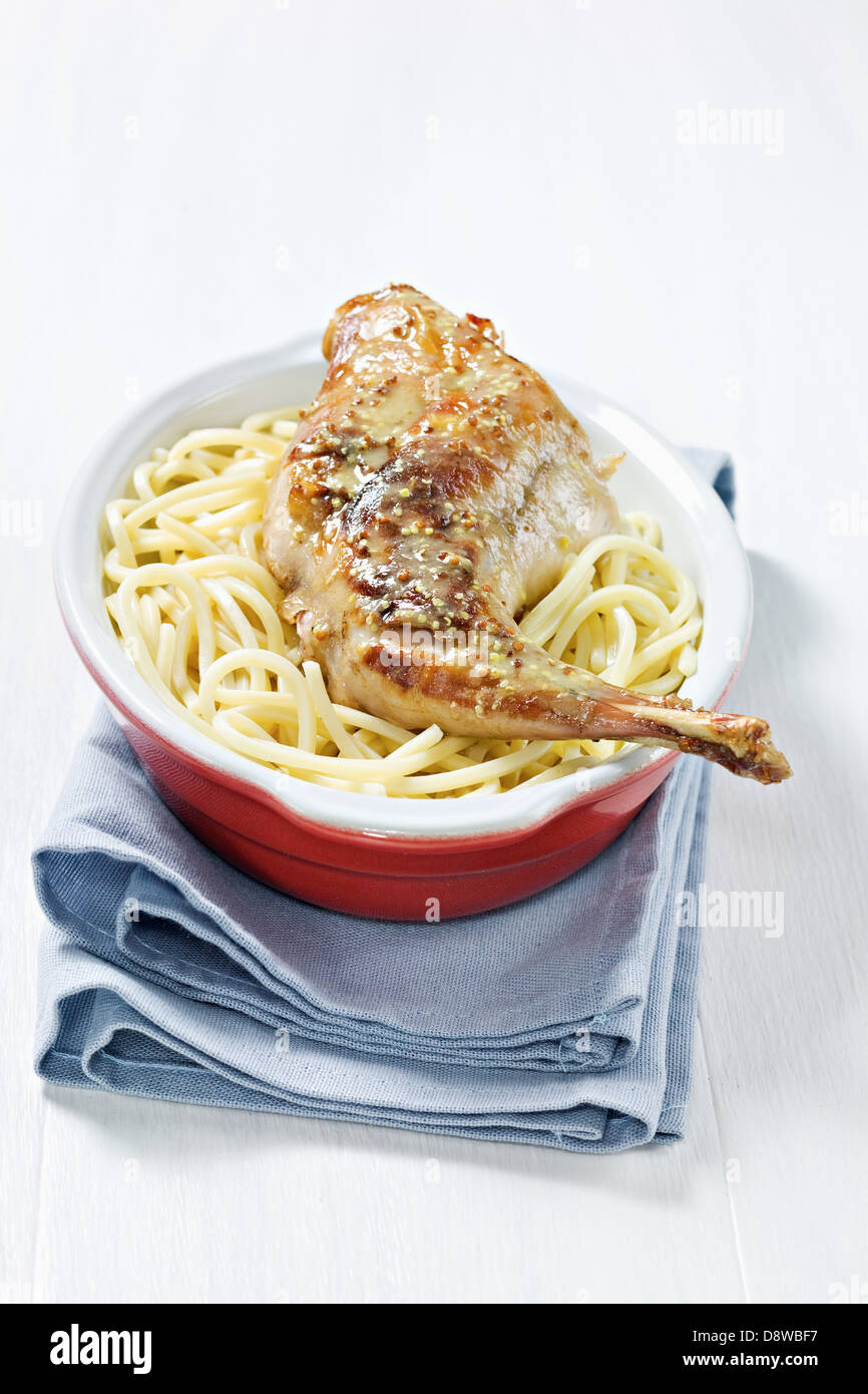 Cuisse de lapin à la moutarde sur un lit de spaghetti Banque D'Images