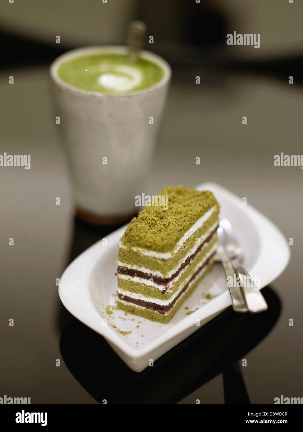 Macha latte et une tranche de gâteau de thé vert Banque D'Images