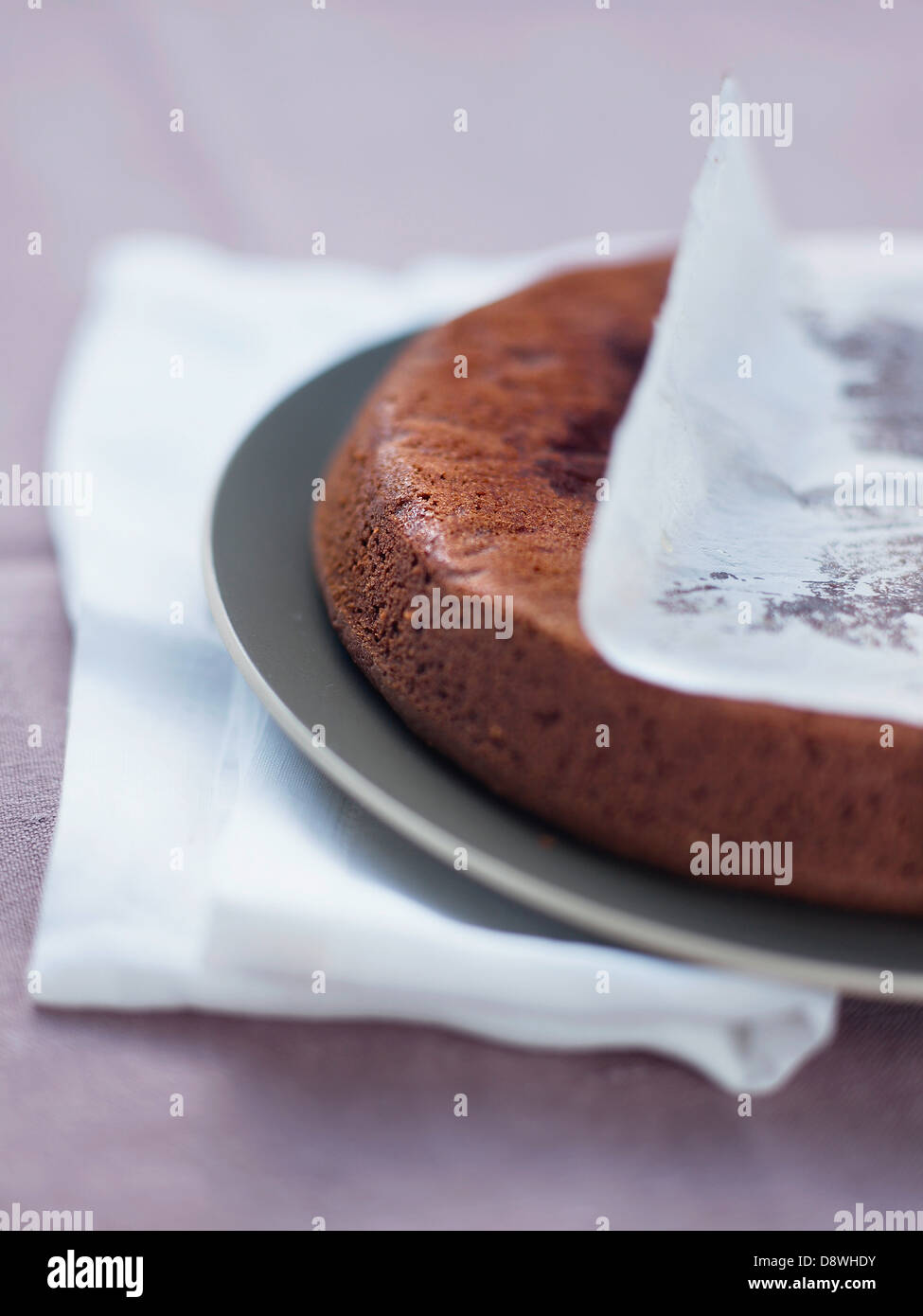 Une fois le gâteau au chocolat hors du moule, retirer le papier ciré Banque D'Images