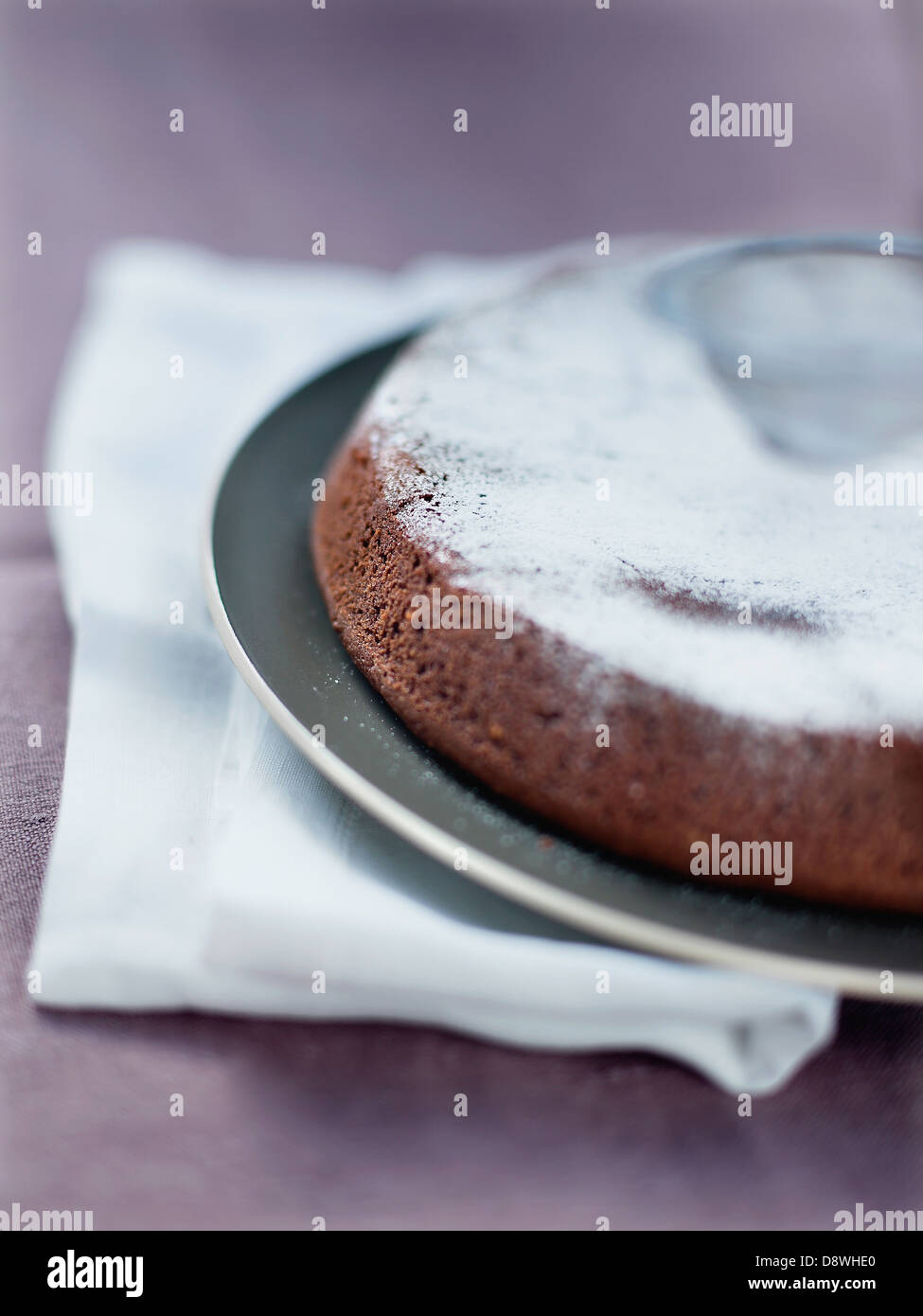 Le Sprinkiling flourless chocolate cake with icing sugar Banque D'Images