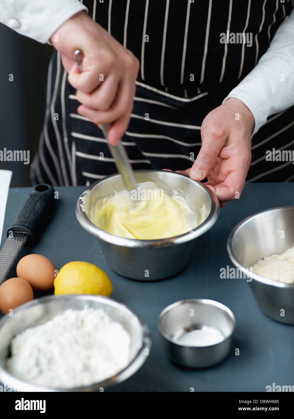 Mélanger ensemble le sucre et le beurre pour la pâte à gâteau Banque D'Images