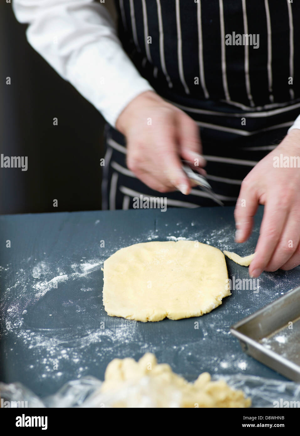 Couper la pâte à gâteau de la taille du moule Banque D'Images