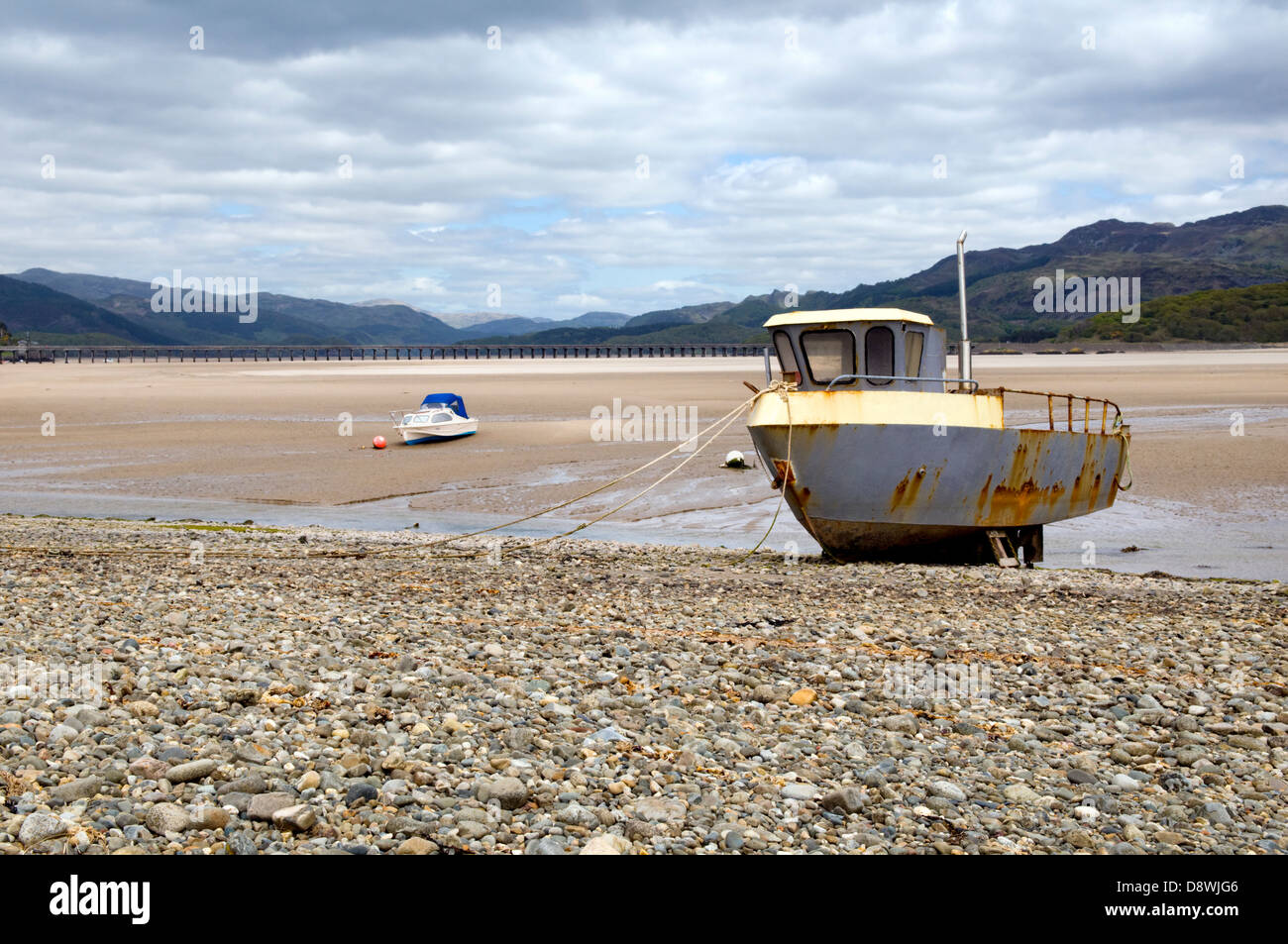 Fairboune Beach sur la côte de la baie de Barmouth, Gwynedd, Pays de Galles, UK avec vieux bateau rouillé et pont à Barmouth la distance Banque D'Images