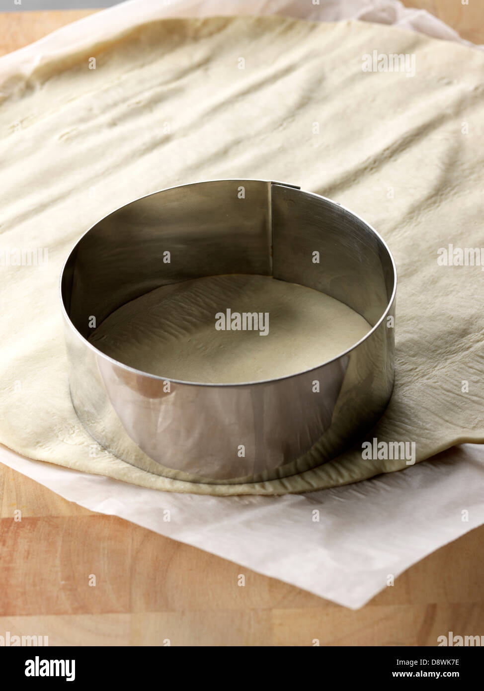 Couper un cercle dans la propagation de la pâte à tarte avec un anneau métallique Banque D'Images