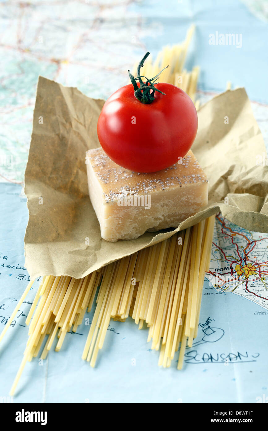 Spaghettis, parmesan et une tomate sur une carte routière de l'Italie Banque D'Images