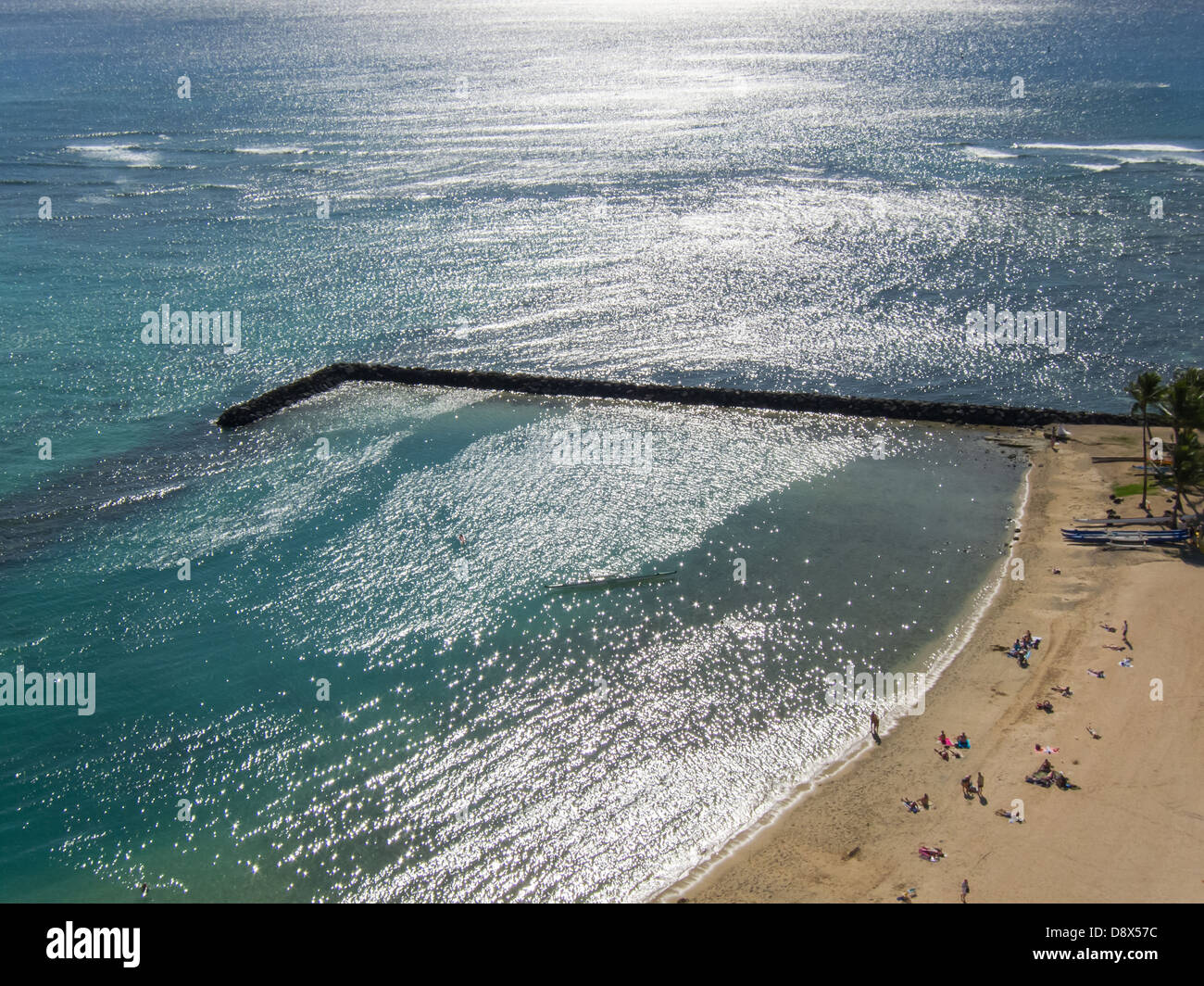 Jetée sur une plage de Waikiki avec la lumière du soleil brille reflète dans l'eau Banque D'Images