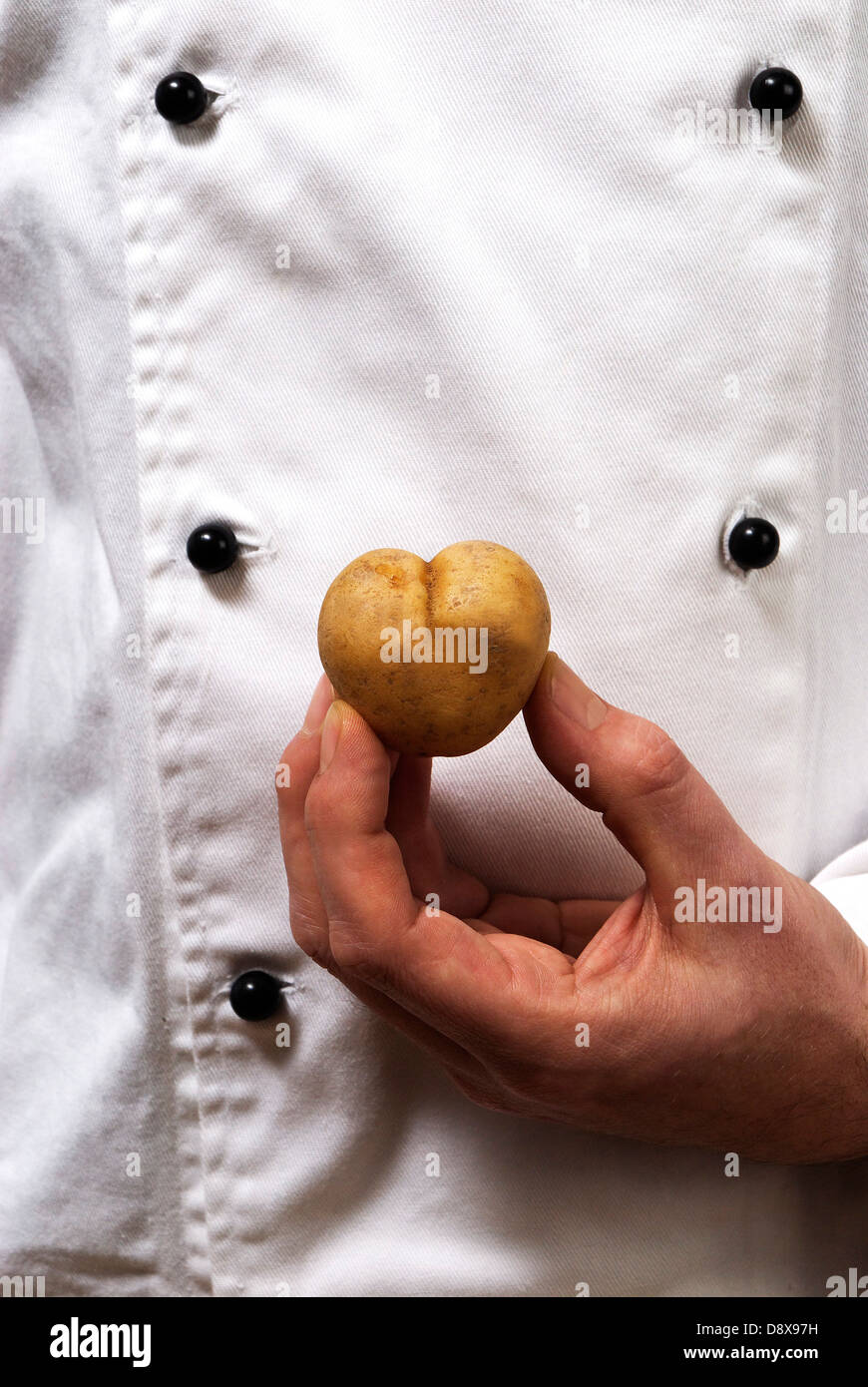 Un cuisinier avec une pomme de terre en forme de coeur Banque D'Images