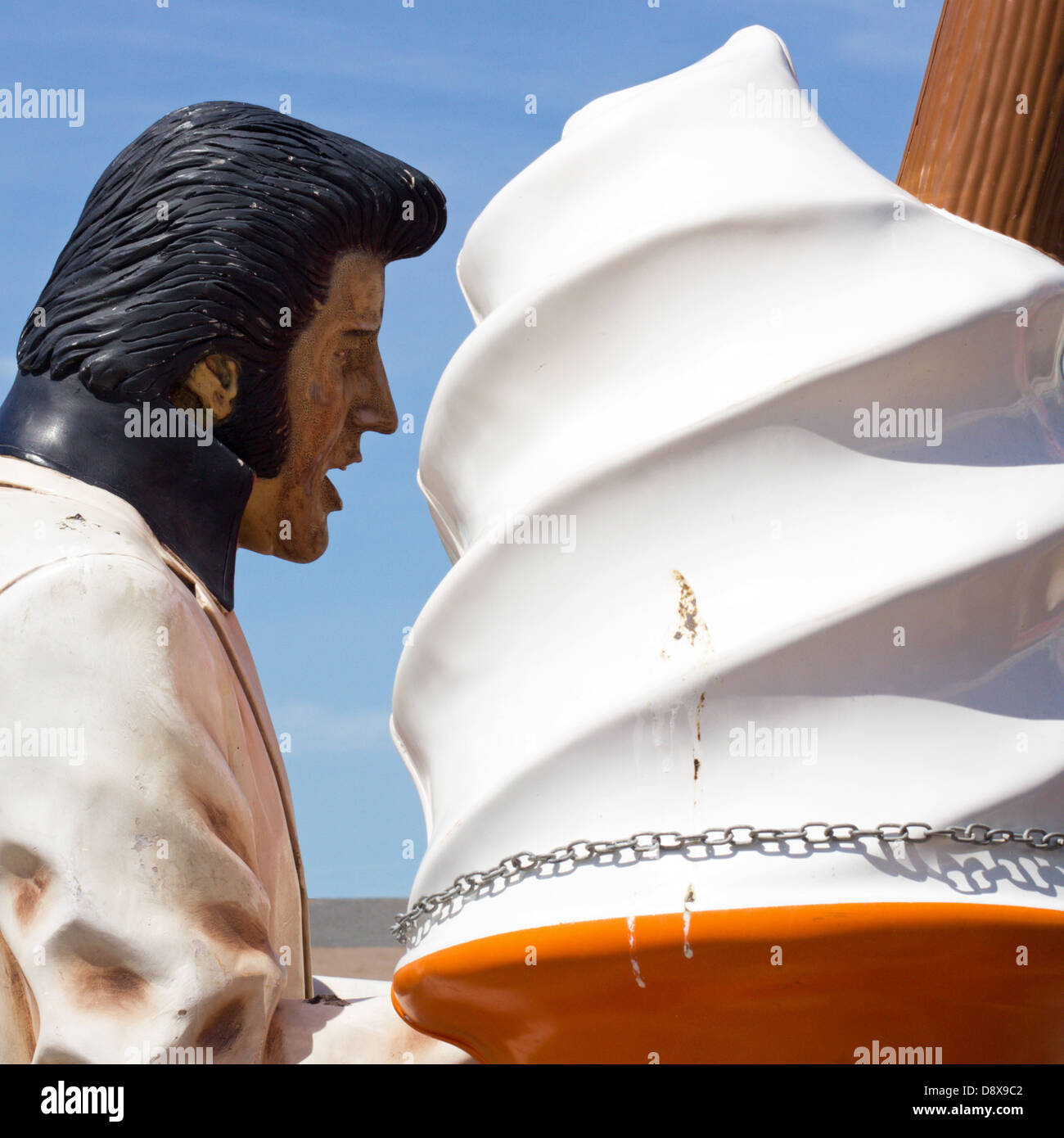 Mannequin Elvis géant ressemble à ce qu'il est en train de manger un énorme cornet de crème glacée - journée ensoleillée au bord de la mer à Brighton, East Sussex, UK. Banque D'Images