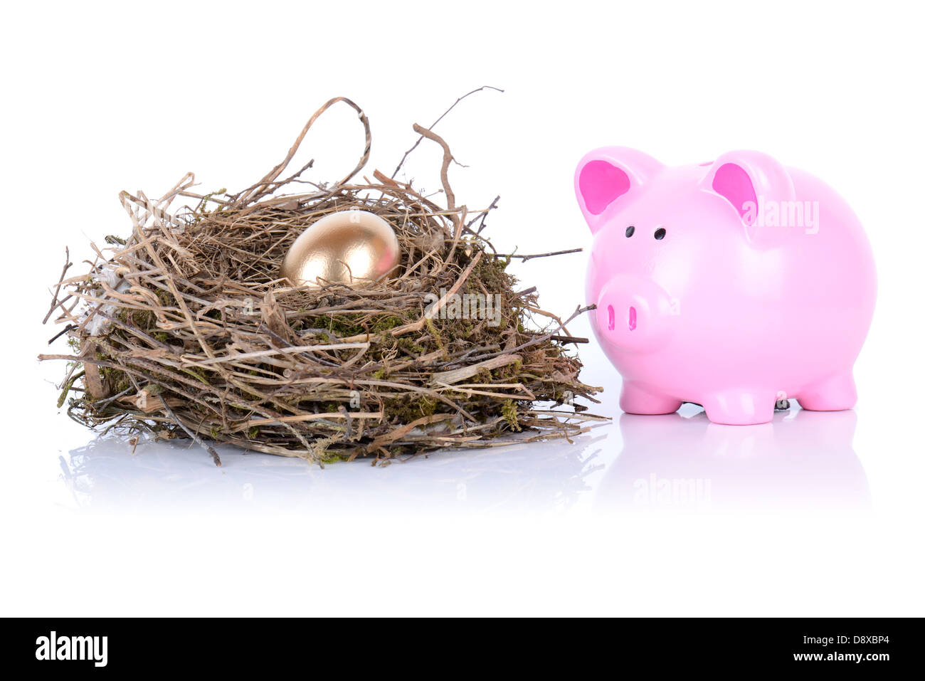 Tirelire à après golden egg in nest isolated on white Banque D'Images