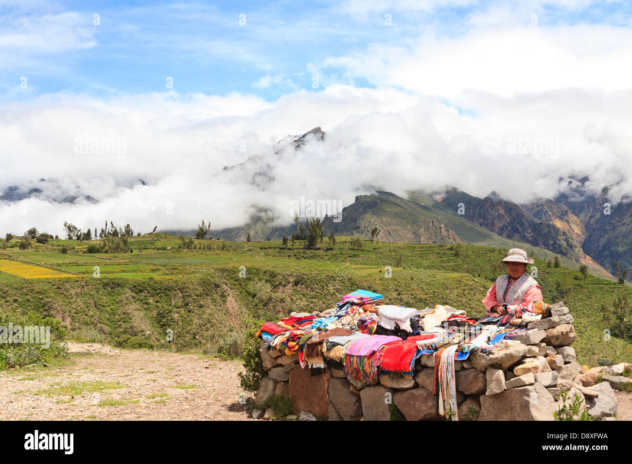 Femme autochtone debout à côté de son étal et la vente de souvenirs, Canyon de Colca, Pérou Banque D'Images