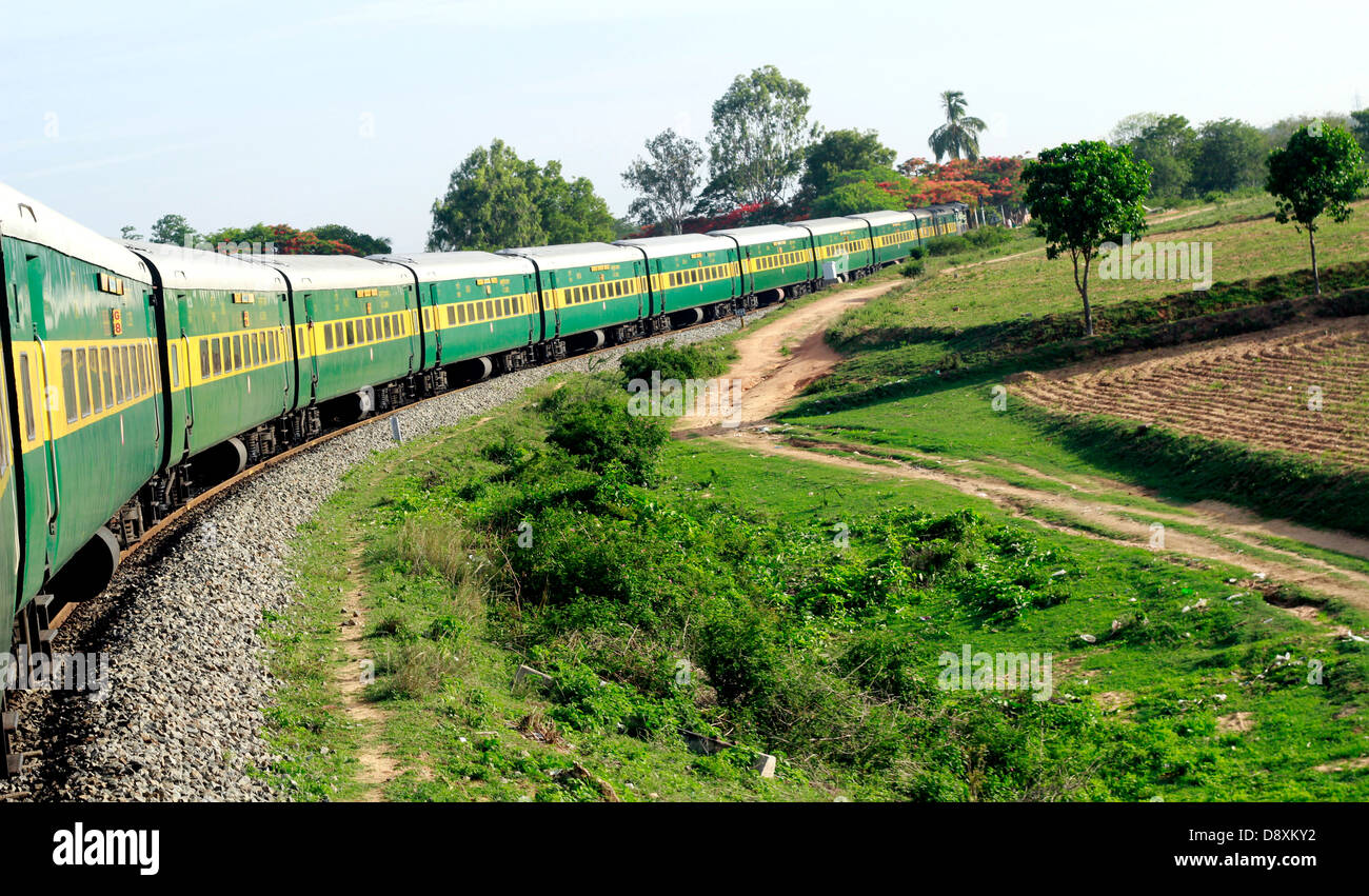 Un train des chemins de fer indiens (Garib rath) une courbe de manoeuvres dans les Ghâts occidentaux, Tamil Nadu, Inde. Banque D'Images