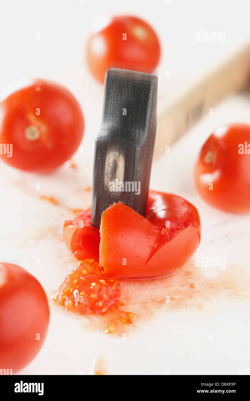 Écraser les tomates avec un marteau Banque D'Images
