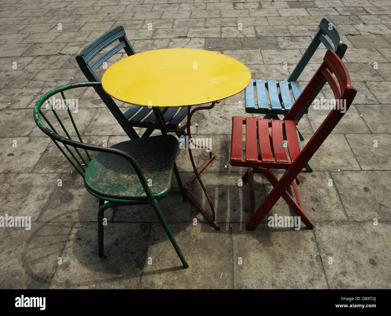 Chaises et tables de différentes couleurs dans un restaurant en plein air. Banque D'Images