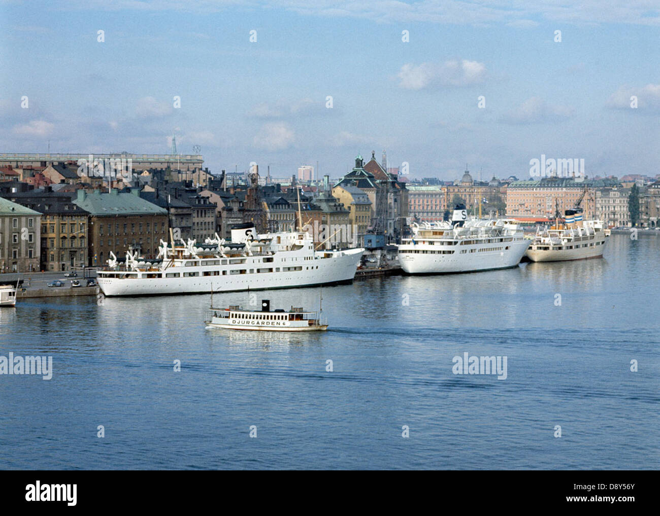 Cette image offre une vue sur le port de Stockholm en 1960, avec des navires et la zone portuaire animée. La photographie met en lumière l’histoire maritime de la ville ainsi que le rôle du port dans le transport et le commerce. Banque D'Images