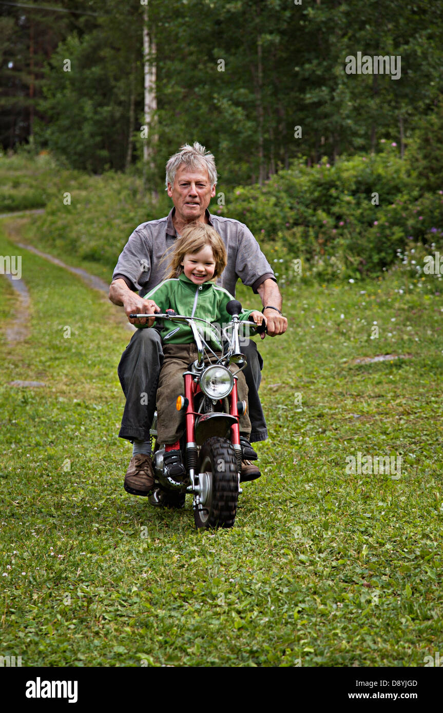 Grand-père et un petit-fils sur une petite mobylette, la Suède. Banque D'Images