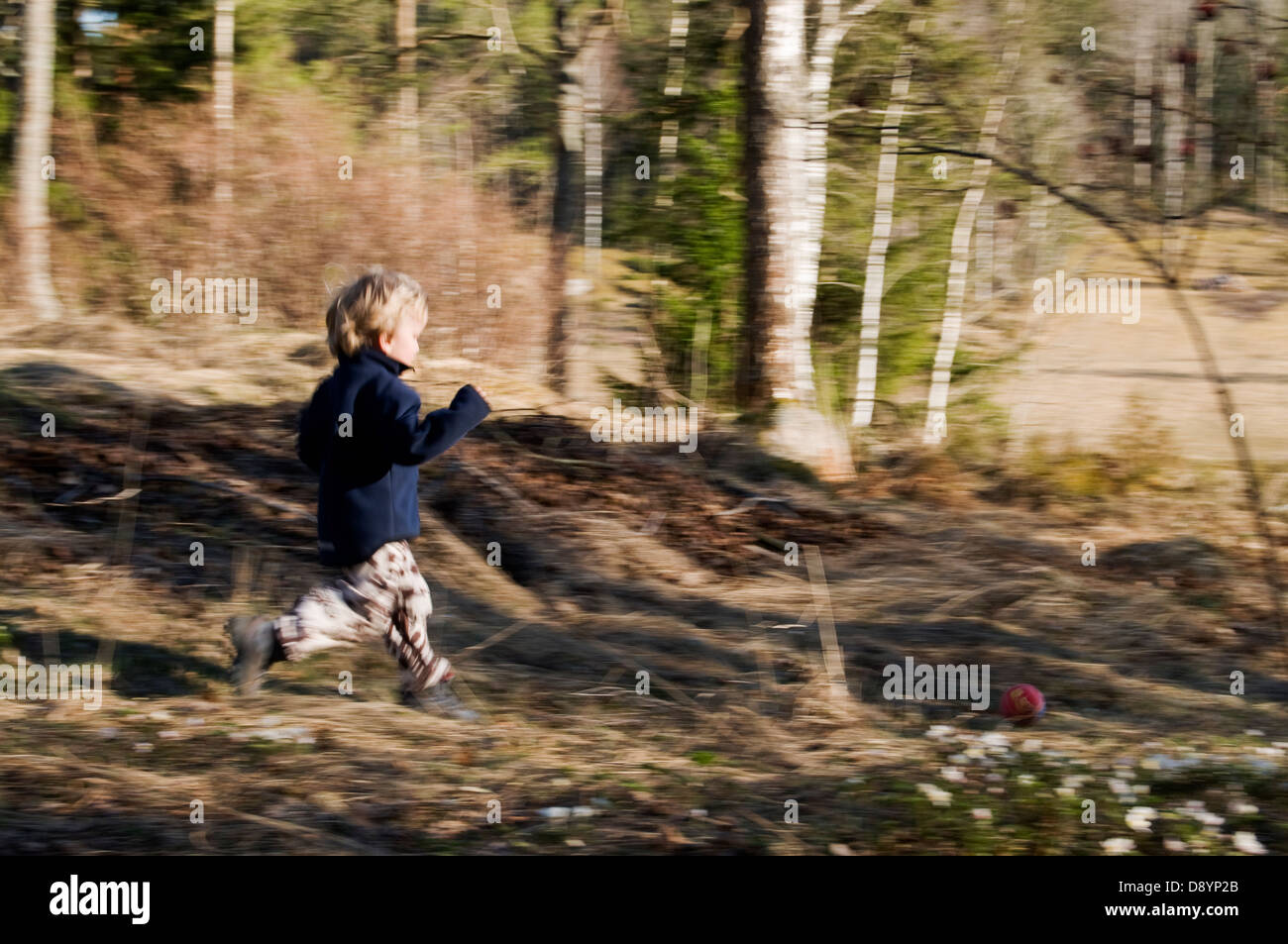 Petit boy running in forest Banque D'Images