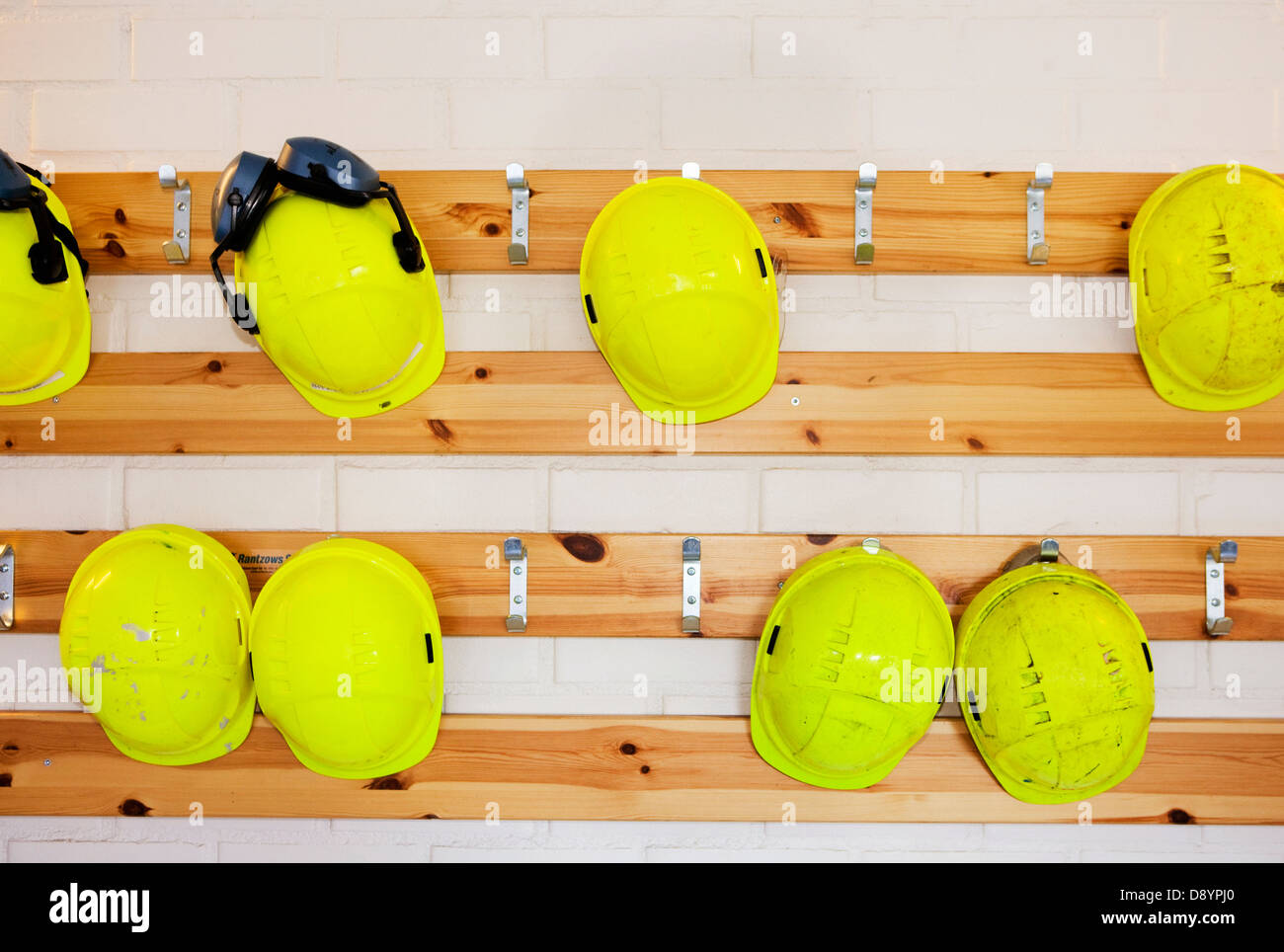 Casque jaune accroché sur rack Banque D'Images