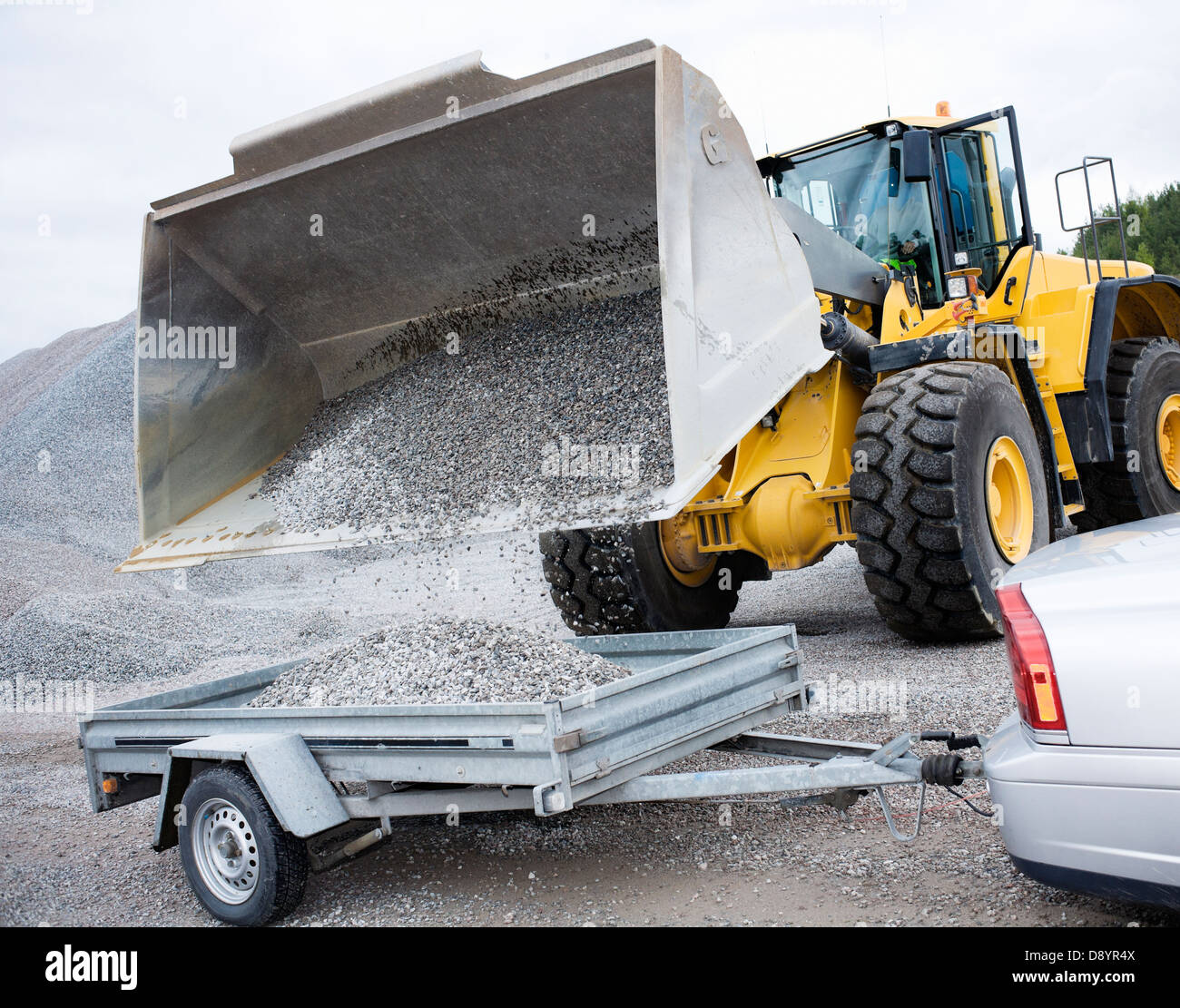 Le gravier est versé par véhicule dans un récipient Banque D'Images