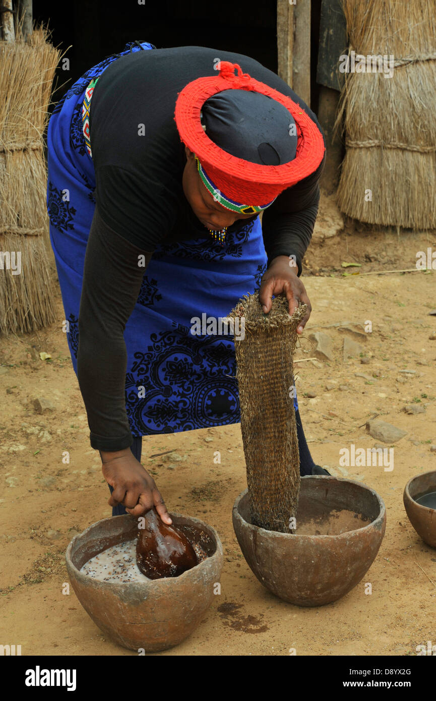 Femme Zulu, tenue traditionnelle, la pression de la bière africaine traditionnelle après la préparation du café, filtre, Shakaland, KwaZulu-Natal, Afrique du Sud, Culture, ethnie Banque D'Images