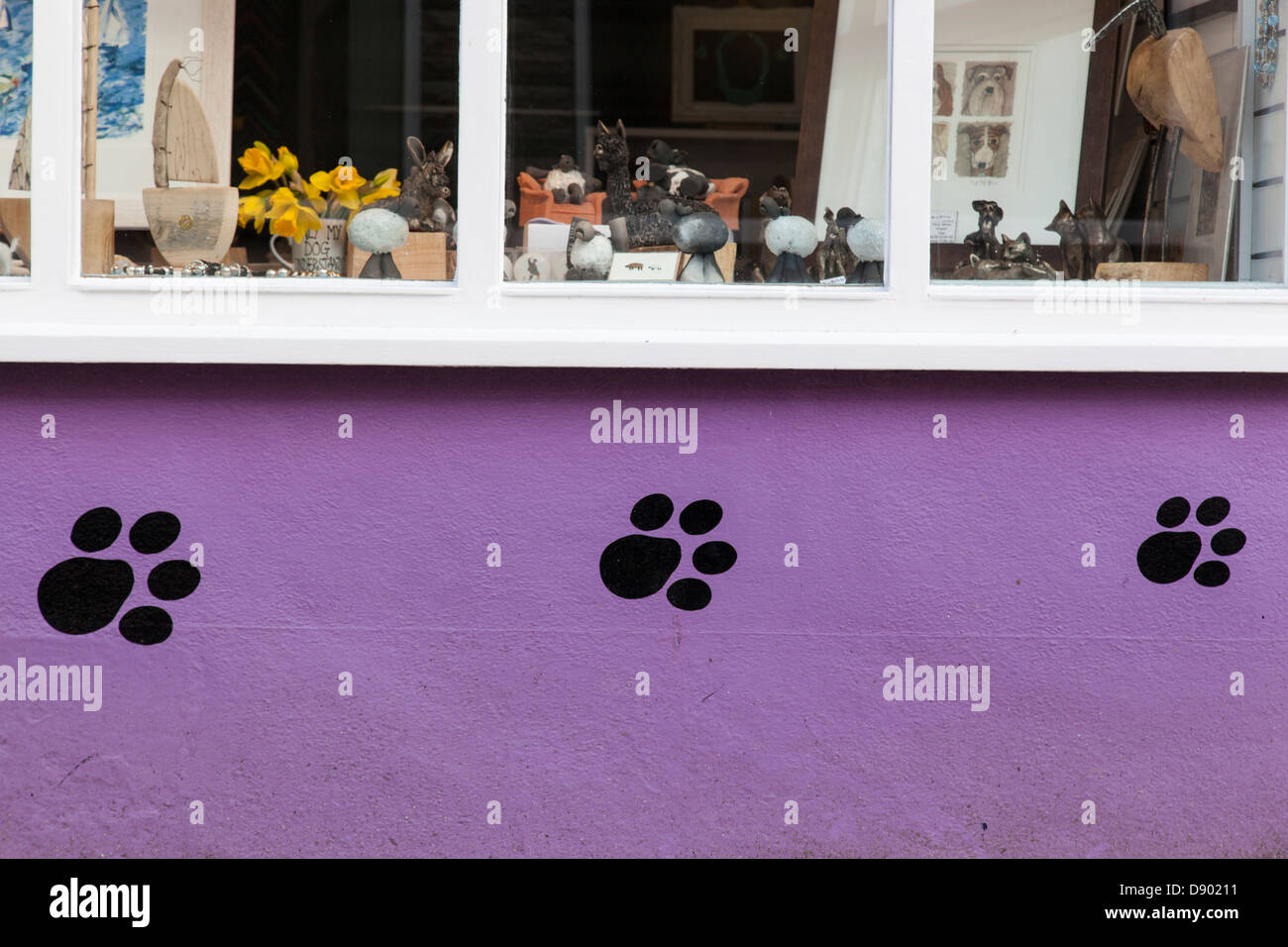 Vitrine avec façade peinte rose décorée avec des empreintes de pattes de chien noir. Banque D'Images