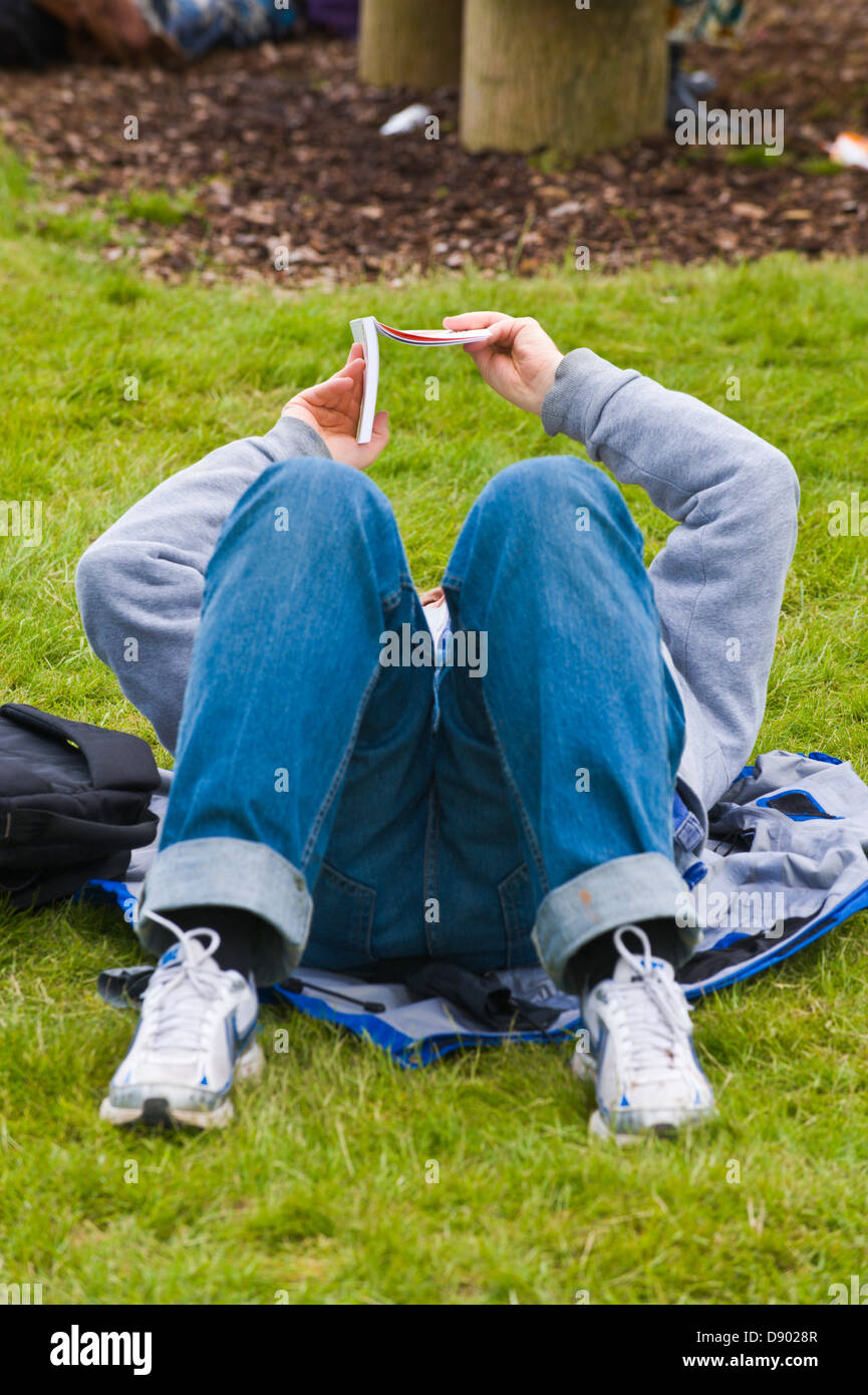 Woman lying on grass reading book au Hay Festival 2013 Hay-on-Wye Powys Pays de Galles UK Banque D'Images