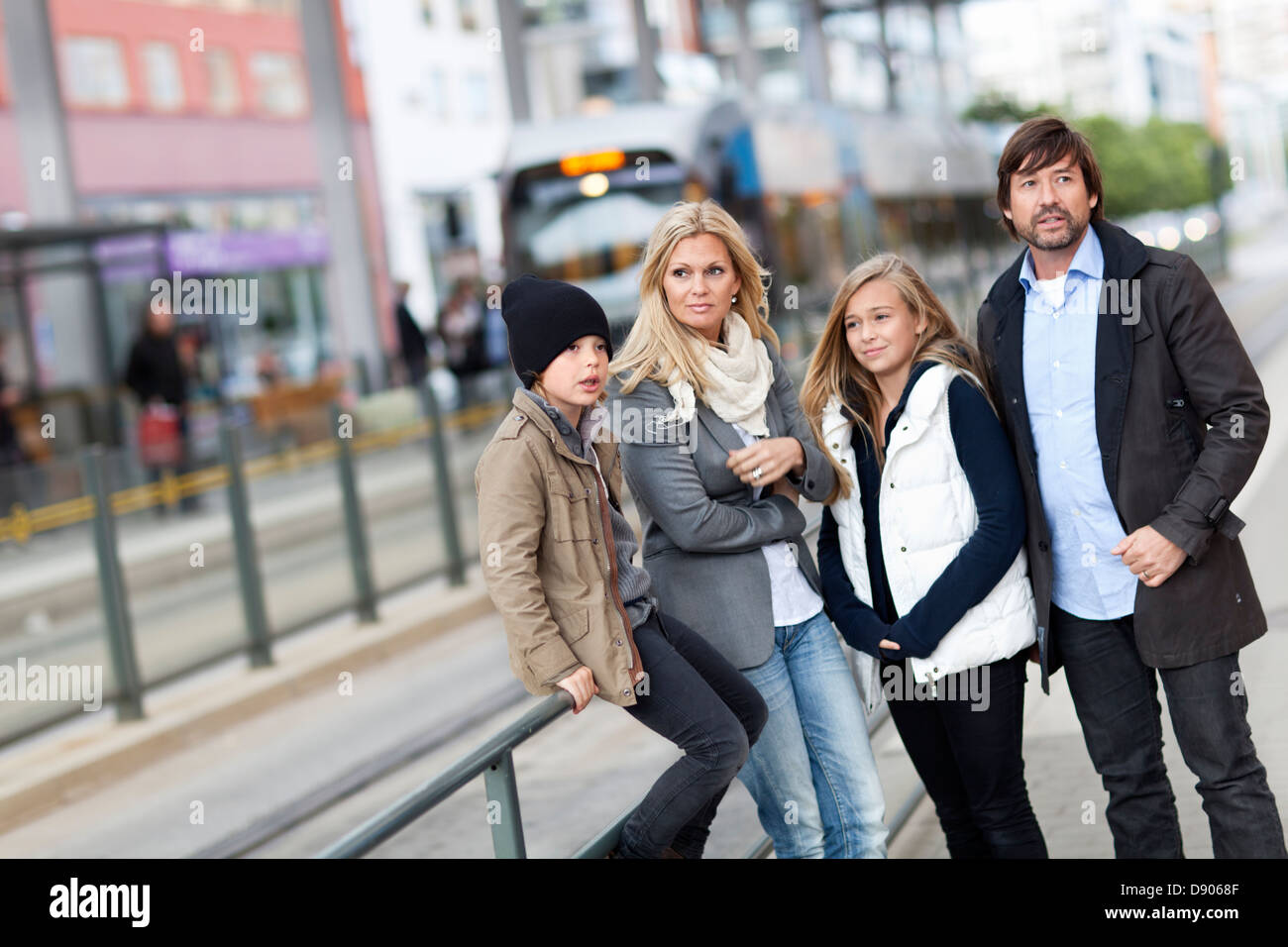 Famille avec deux enfants en attente de tram Banque D'Images