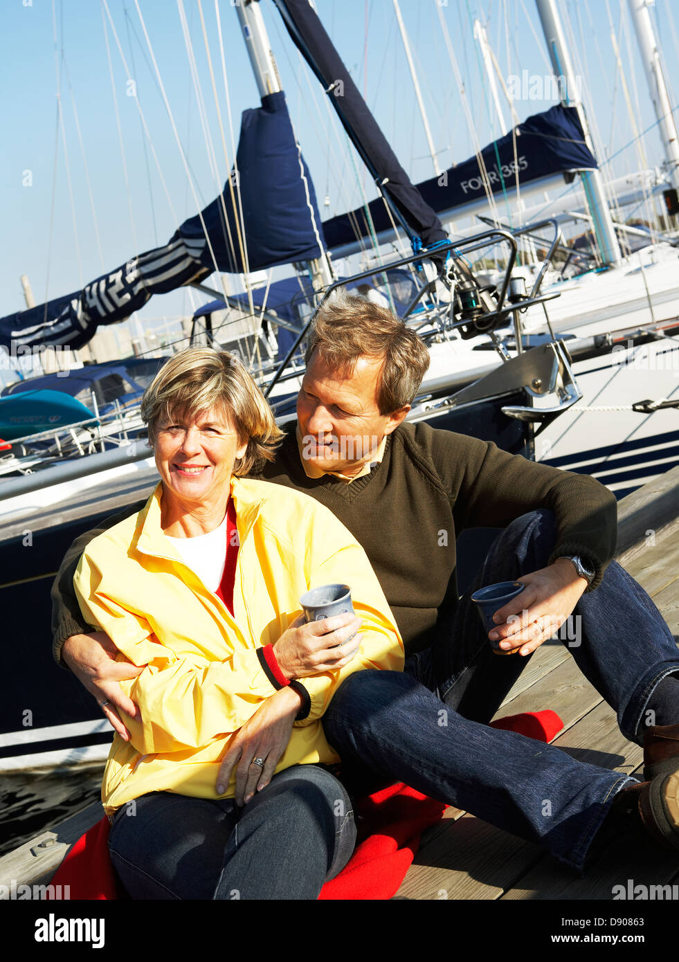 Portrait d'un couple d'âge moyen assis dans un port. Banque D'Images