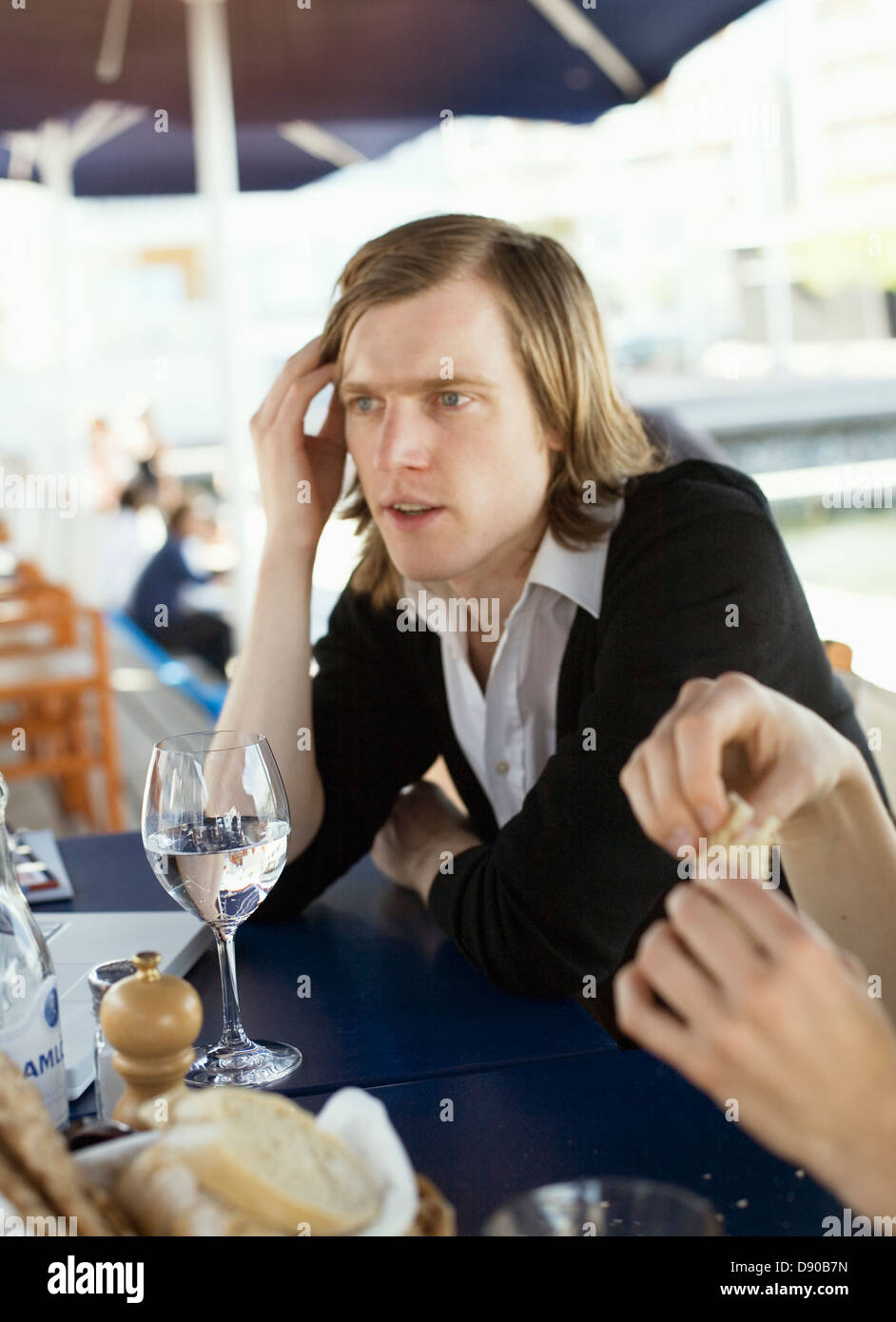 Jeune homme debout par un compteur de barre. Banque D'Images