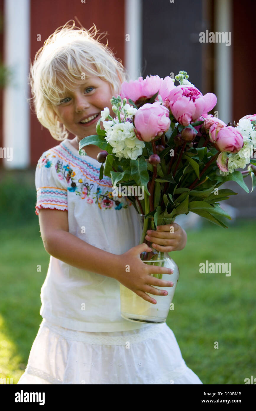 Little girl holding a bouquet de fleurs, Fejan, archipel de Stockholm, Suède. Banque D'Images