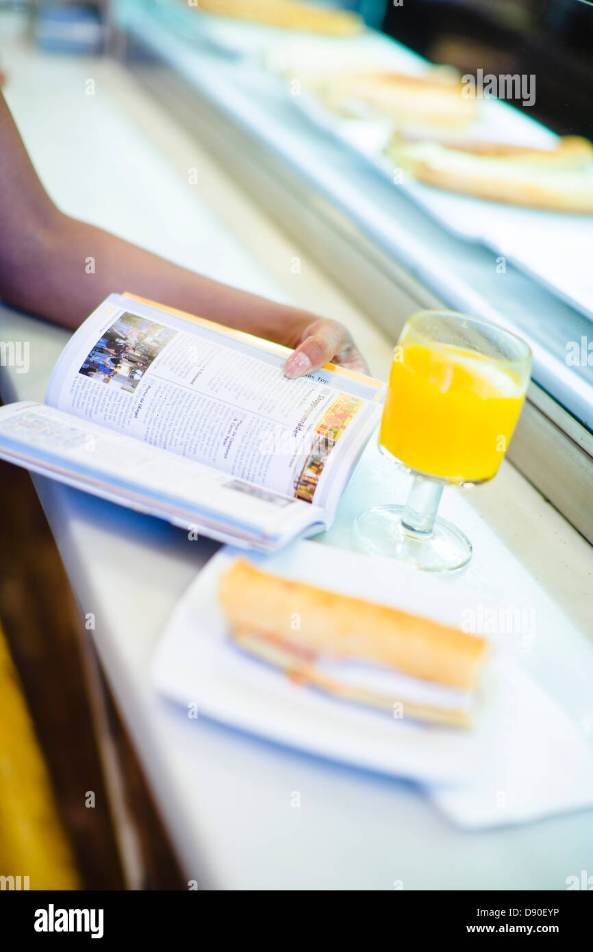 Woman Reading book in cafe Banque D'Images