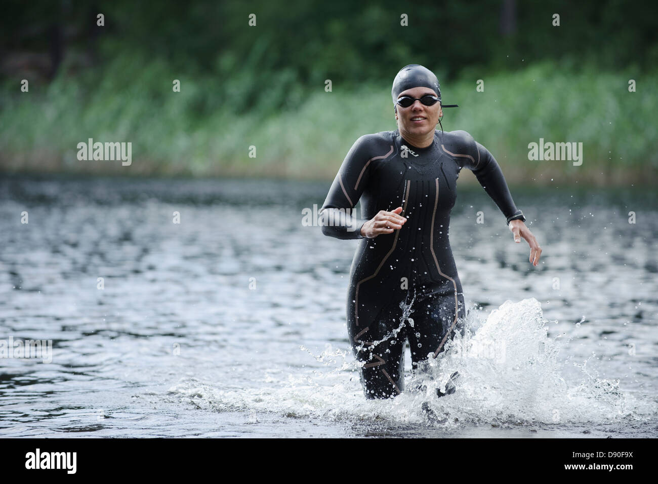Woman running in river Banque D'Images