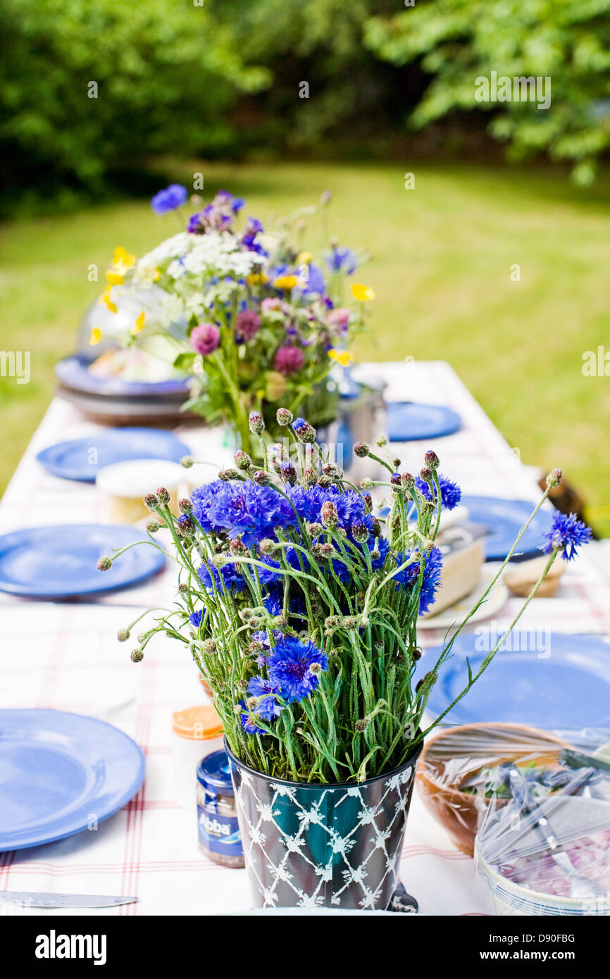 Vase à fleurs et plaques disposées sur une table à manger Banque D'Images