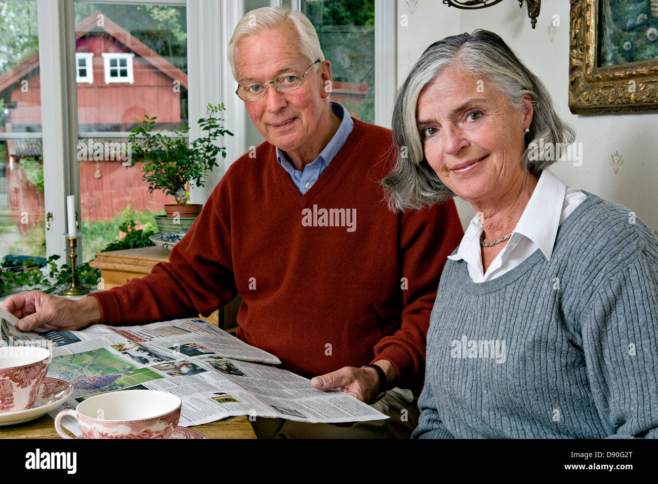 Senior couple reading newspaper à table à manger Banque D'Images