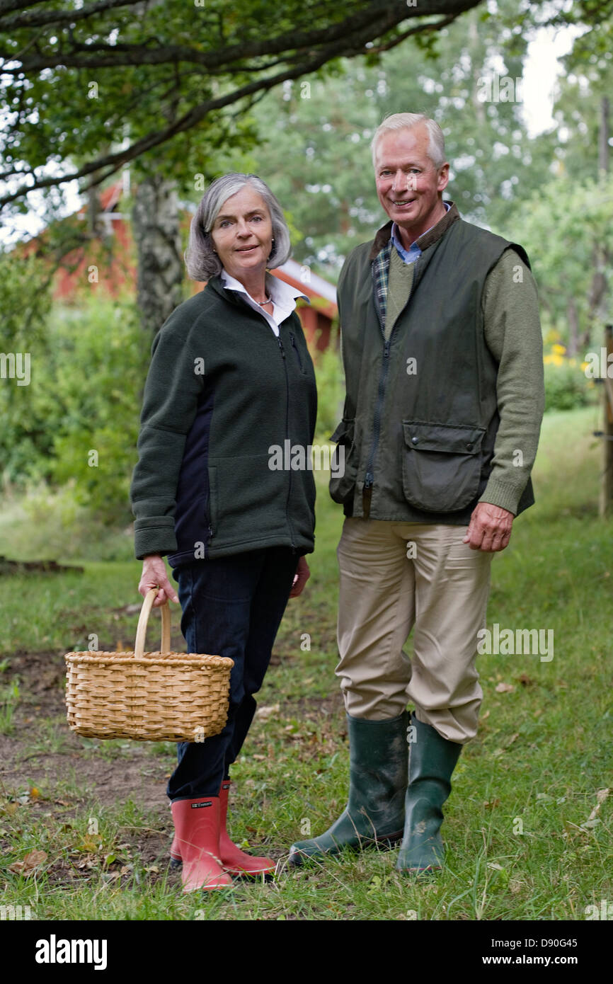 Avec man holding basket, smiling Banque D'Images