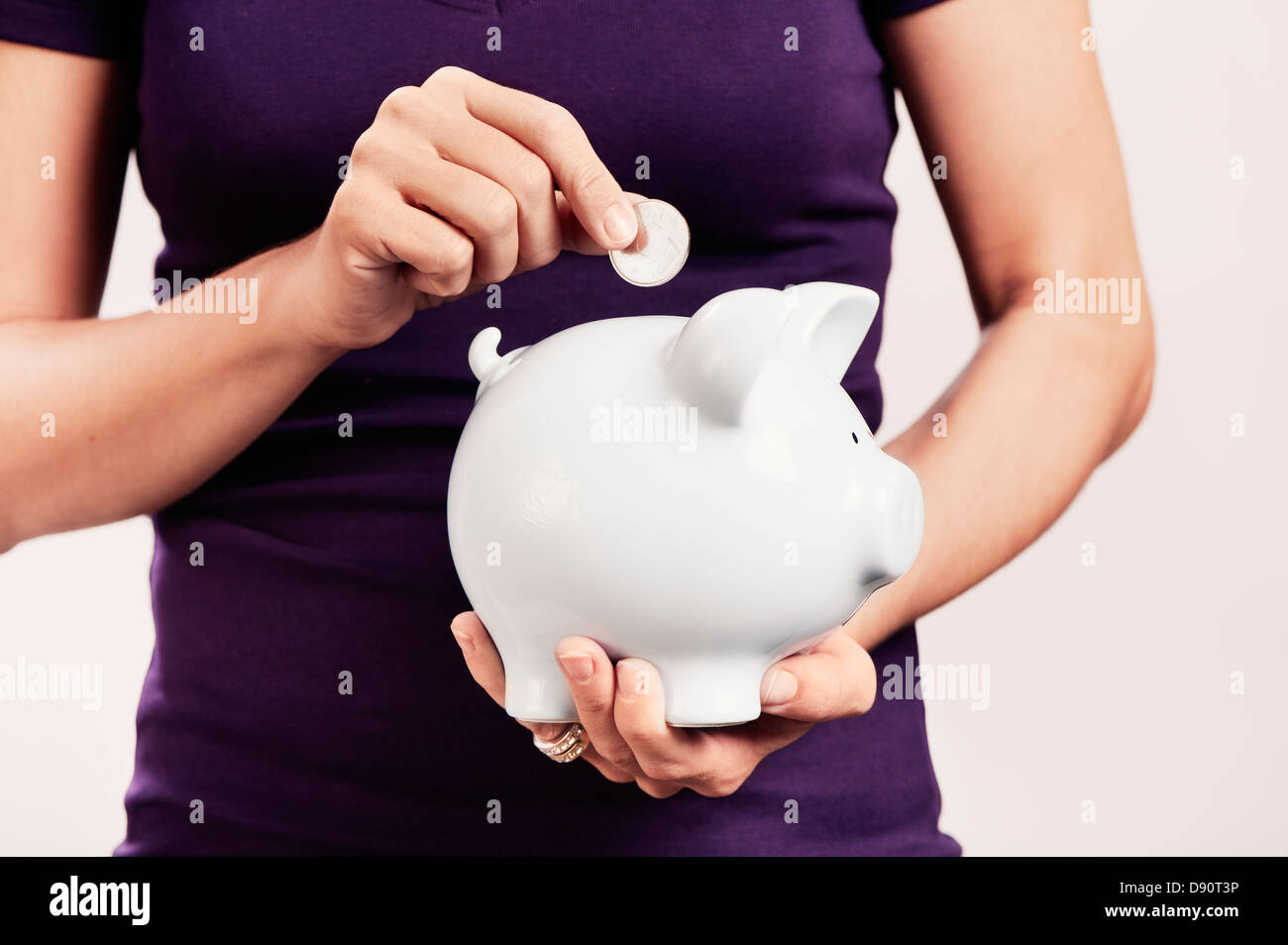 Une femme tenant une boîte d'épargne Banque D'Images