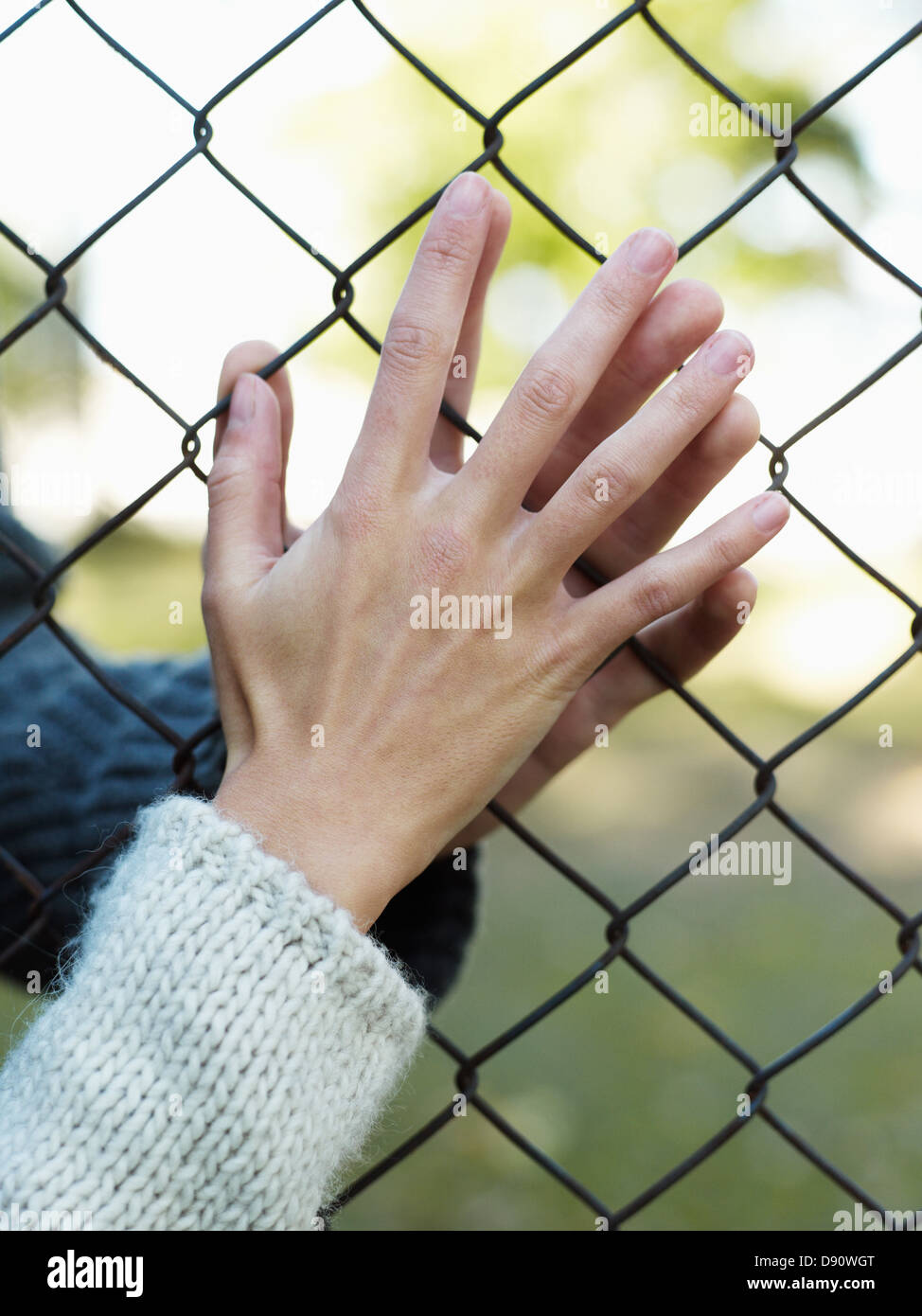 Jeune couple touchant par wire fence Banque D'Images