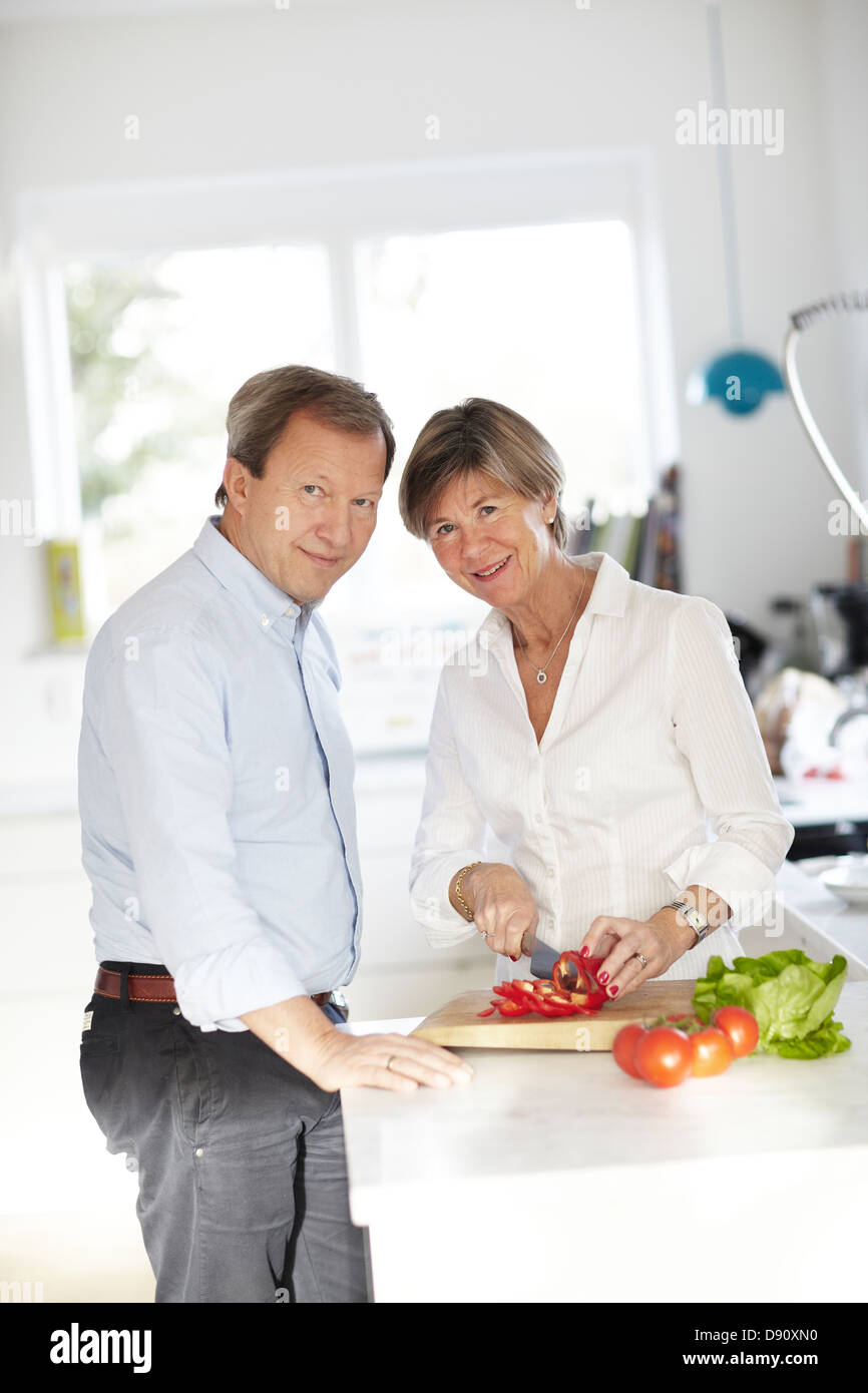 Mature couple preparing food at table Banque D'Images