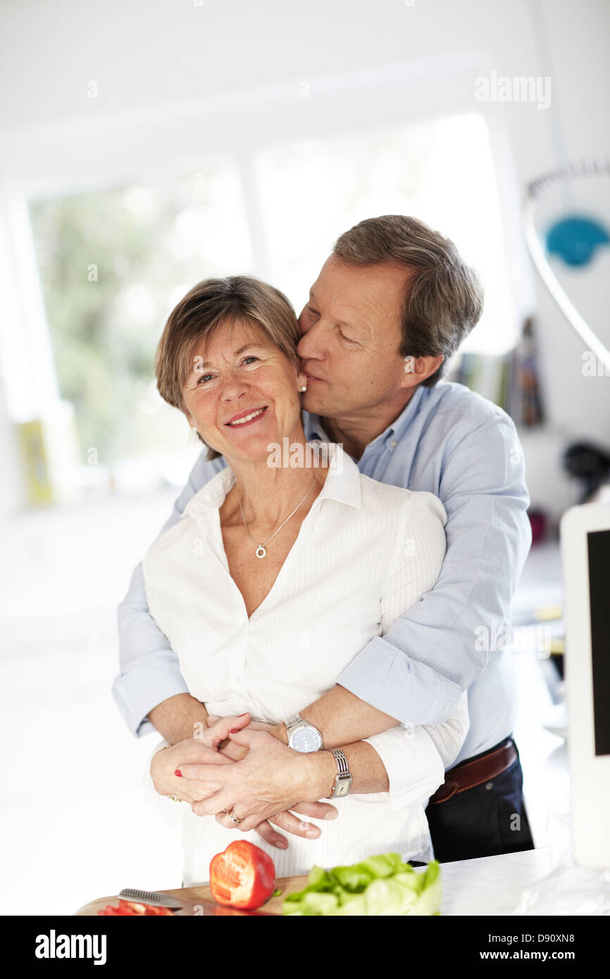 Portrait of mature couple embracing in kitchen Banque D'Images