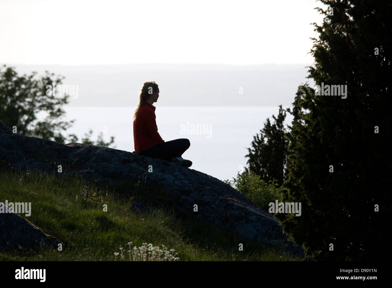 Une femme assise sur une falaise, Granna, Suède. Banque D'Images