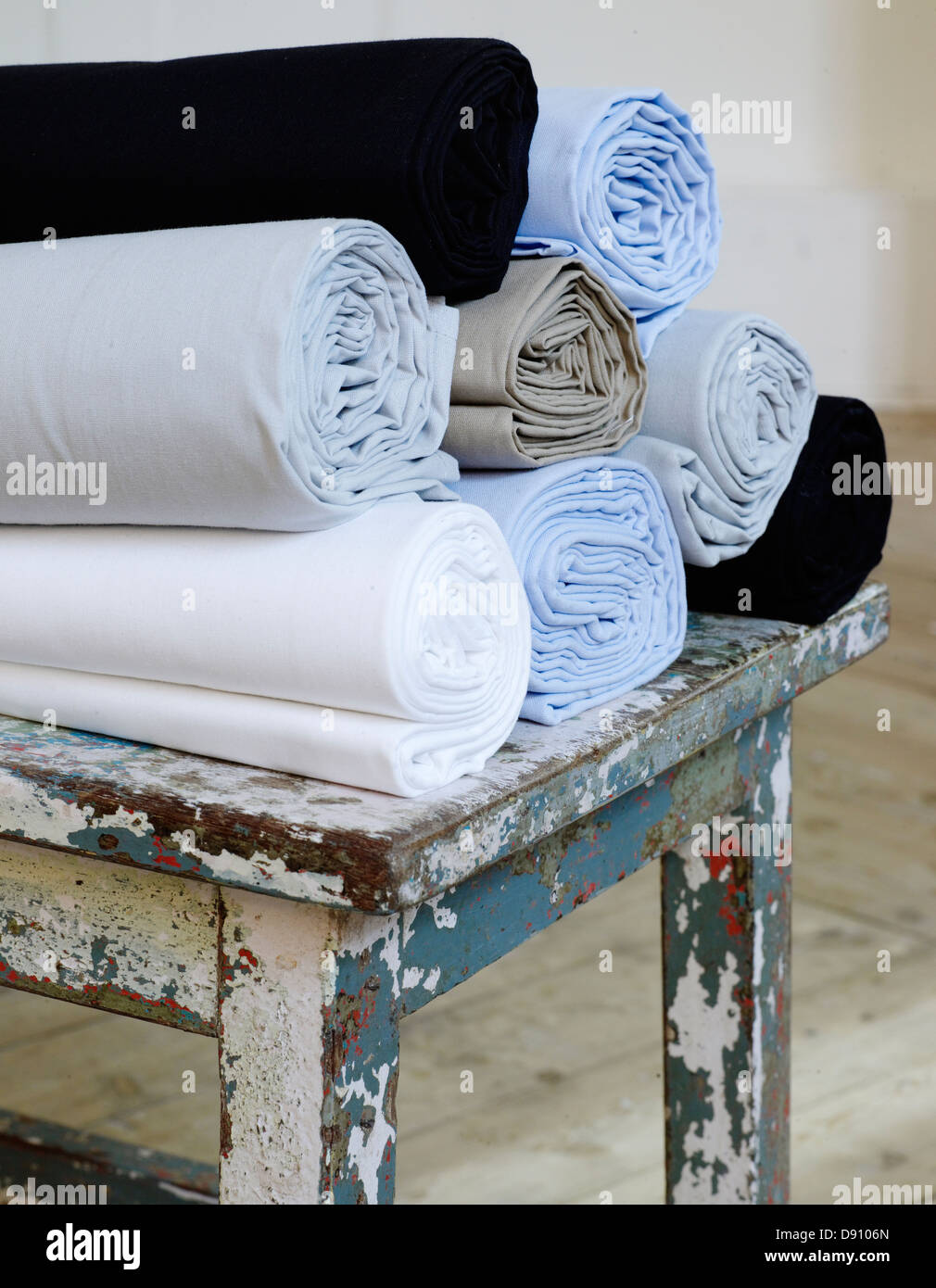 Draps de lit roulé sur table ancienne Banque D'Images