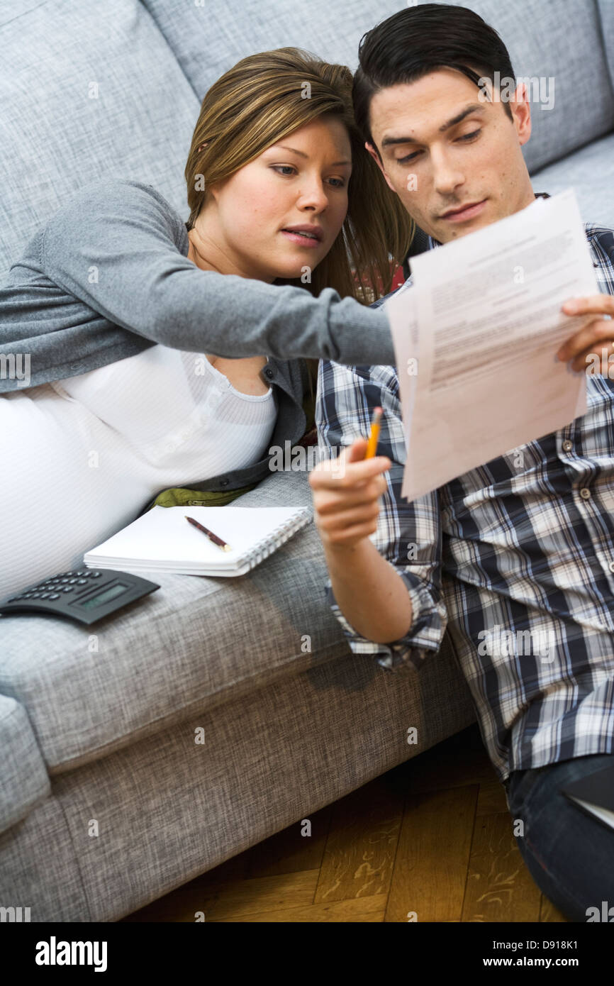 Une femme enceinte et un homme discuter de leurs finances publiques accueil, en Suède. Banque D'Images